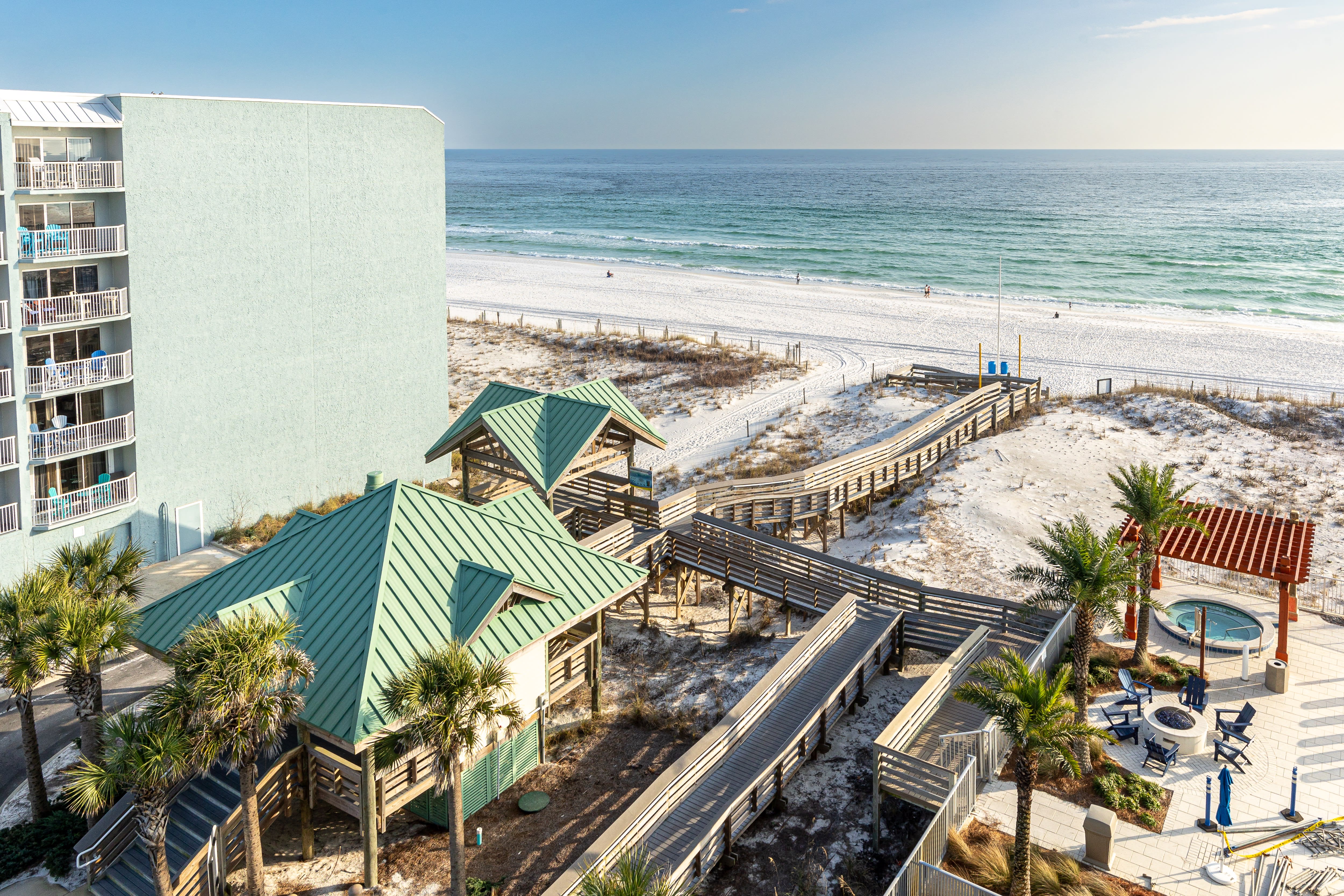 Beachfront property with direct access to pristine white sand beaches and emerald Gulf waters via elevated walkways.