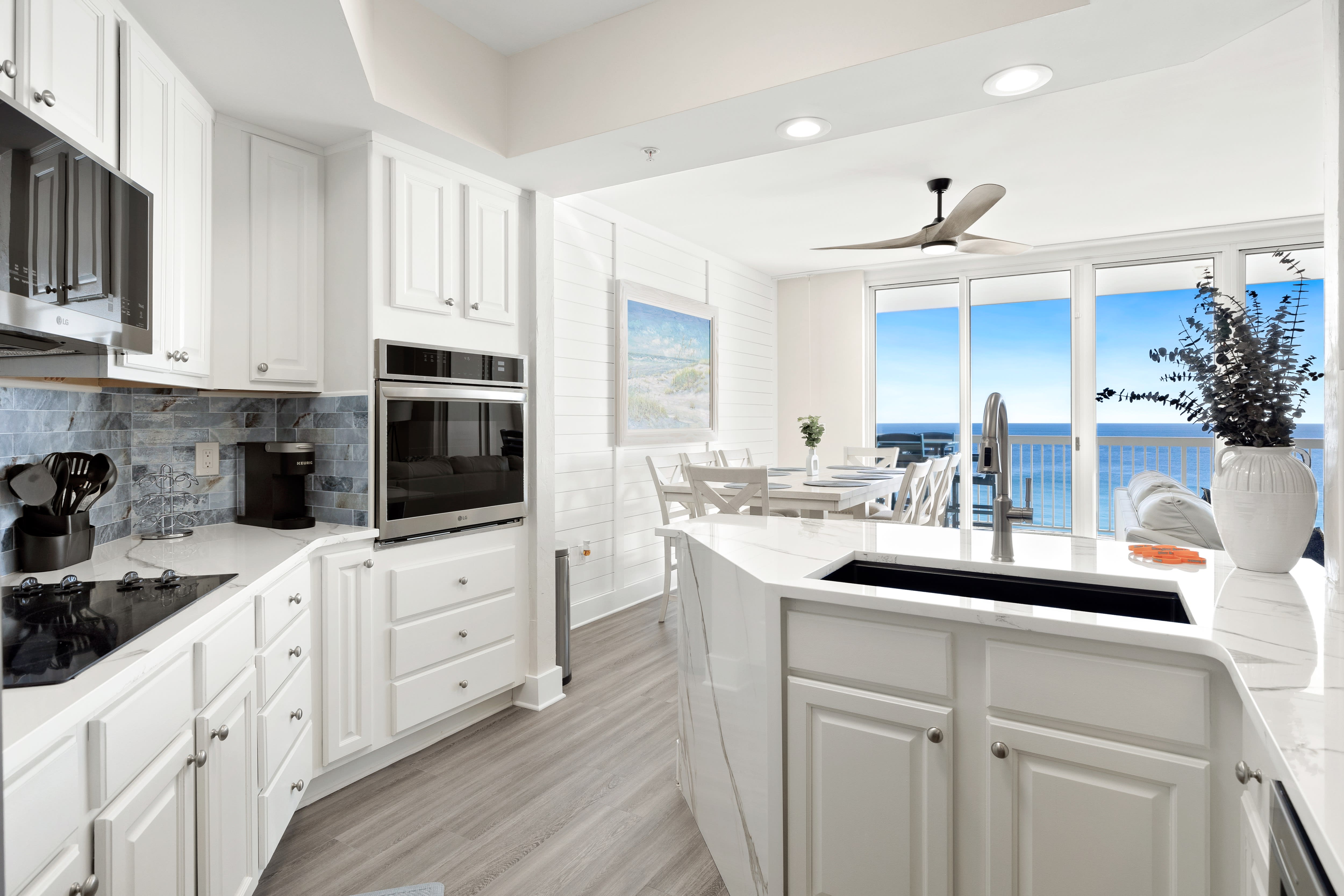 Your pristine white kitchen flows seamlessly to ocean views, where you'll cook with panoramic blue waters as your backdrop through floor-to-ceiling windows.