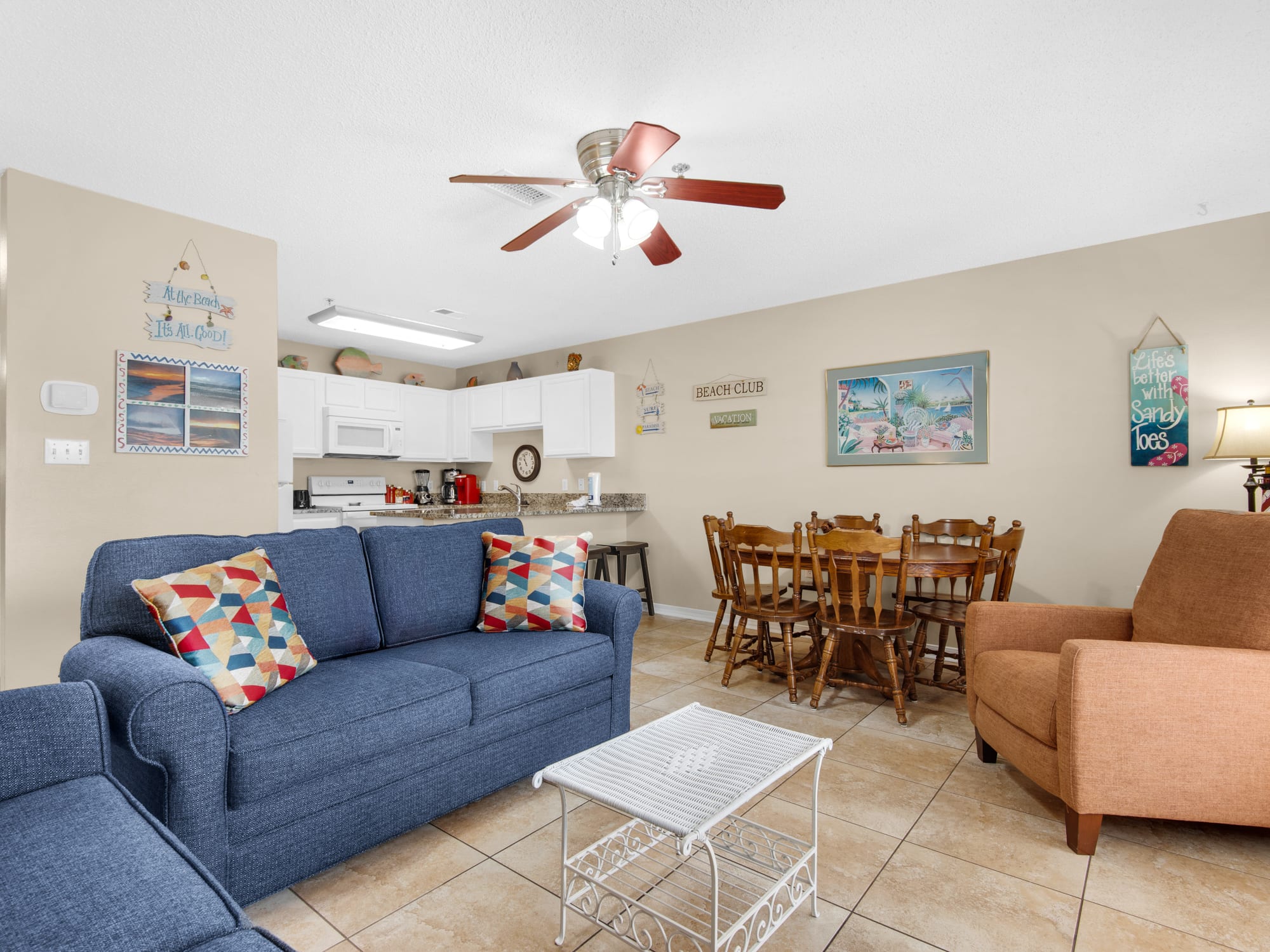 Your bright open-plan living space features a comfy blue sofa, dining table for six, and fully equipped kitchen—perfect for gathering with family.