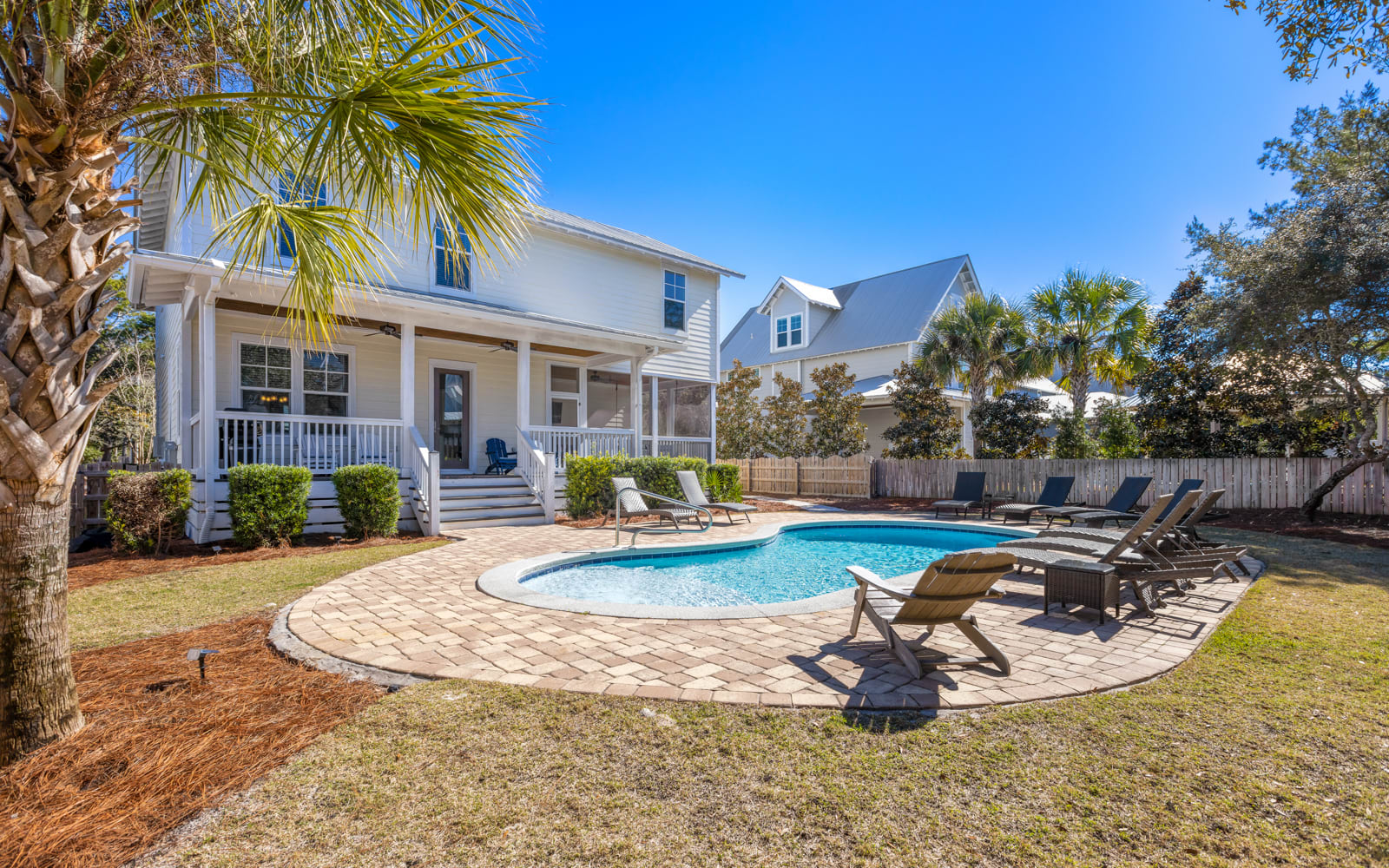 Beautiful coastal home with private pool surrounded by swaying palms and comfortable loungers for the perfect Florida getaway.