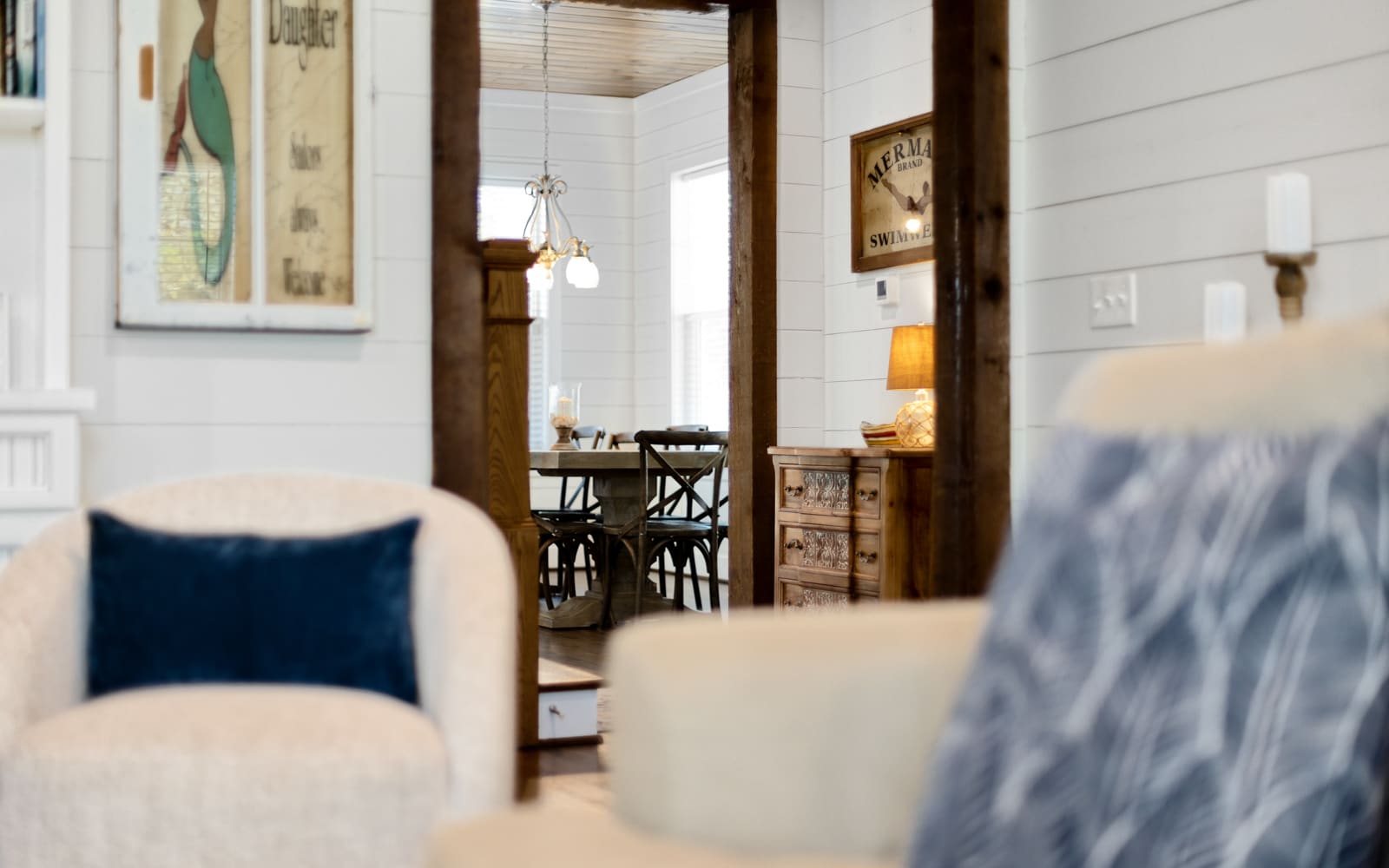 Sink into plush seating in your charming cottage-style retreat, where nautical touches and warm wood beams create the perfect coastal escape.