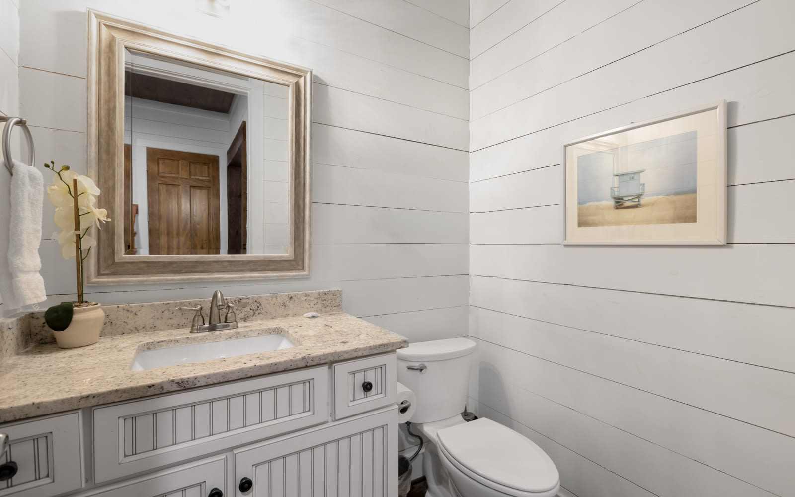 You'll love this bright bathroom with its coastal charm and granite counters for your morning routine.