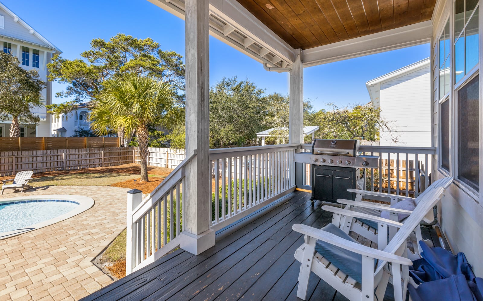 Your covered deck offers a perfect spot to grill and relax, overlooking the sparkling pool and tropical landscaping below.