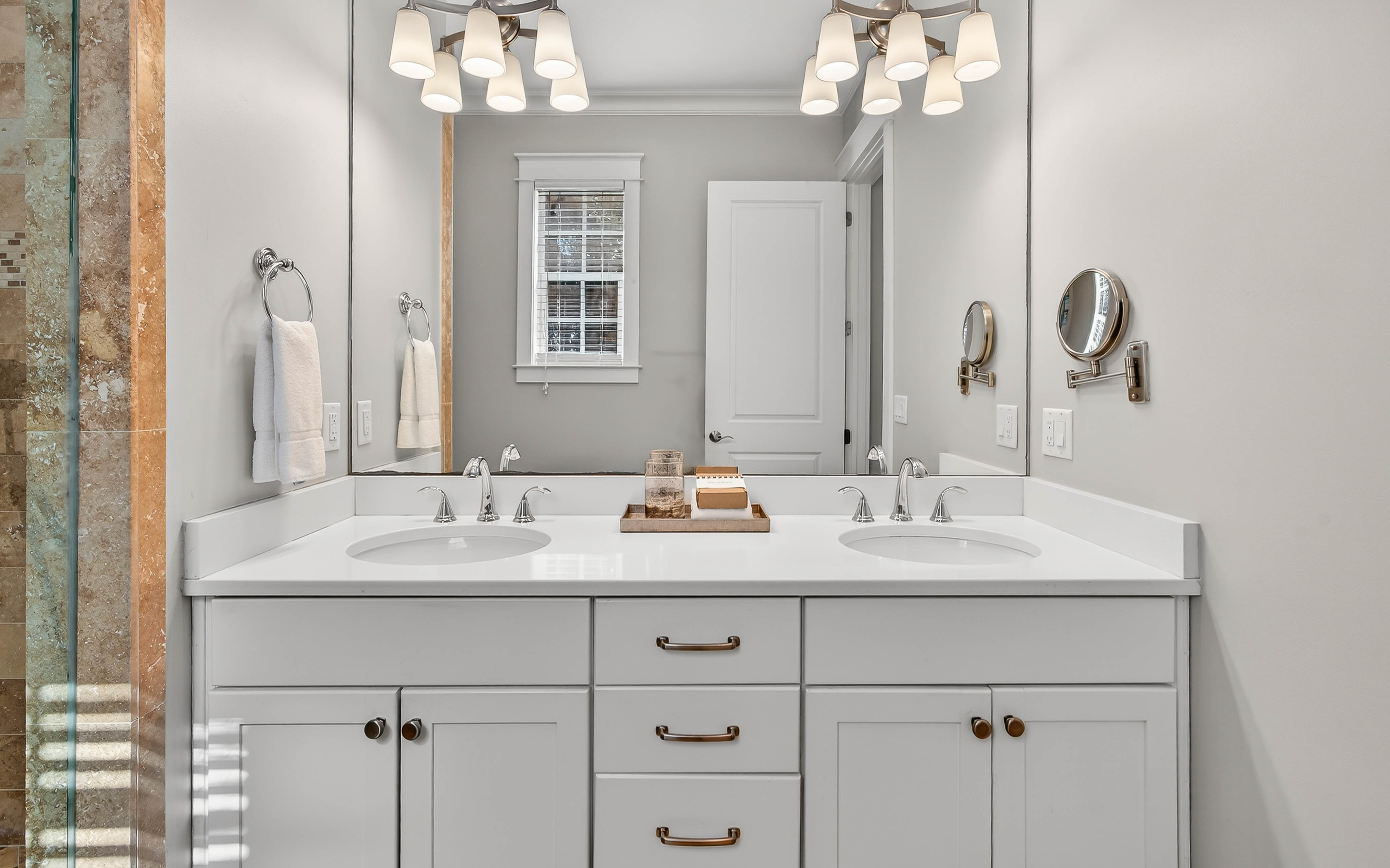 Step into your private spa-like bathroom with dual vanities, elegant lighting, and fresh towels awaiting your arrival.