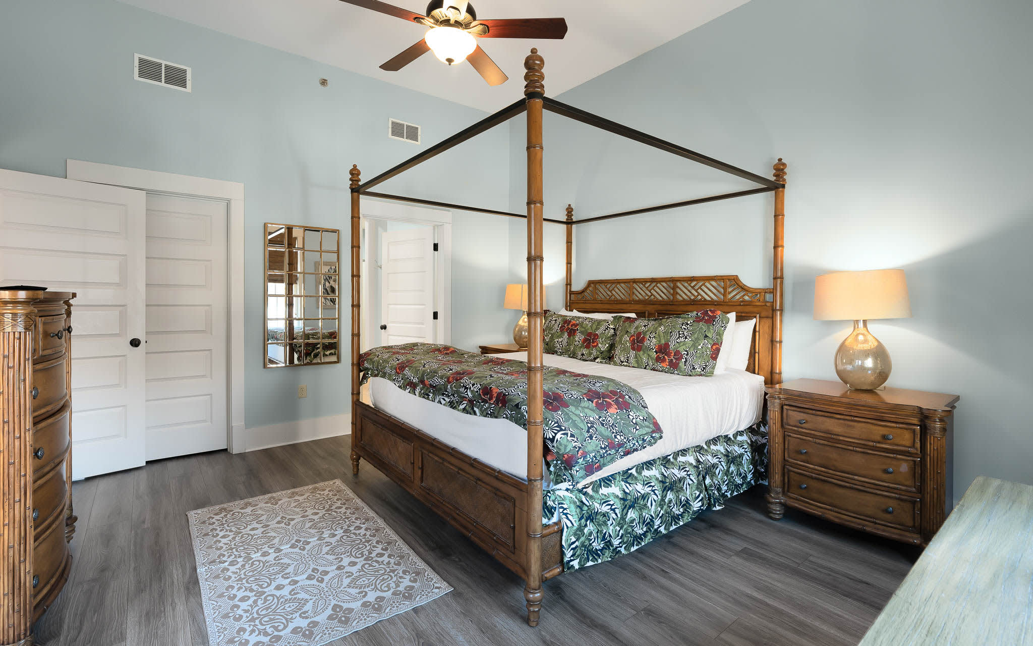 Unwind in your elegant four-poster bed surrounded by soothing coastal hues and tropical bedding that whispers of island dreams.