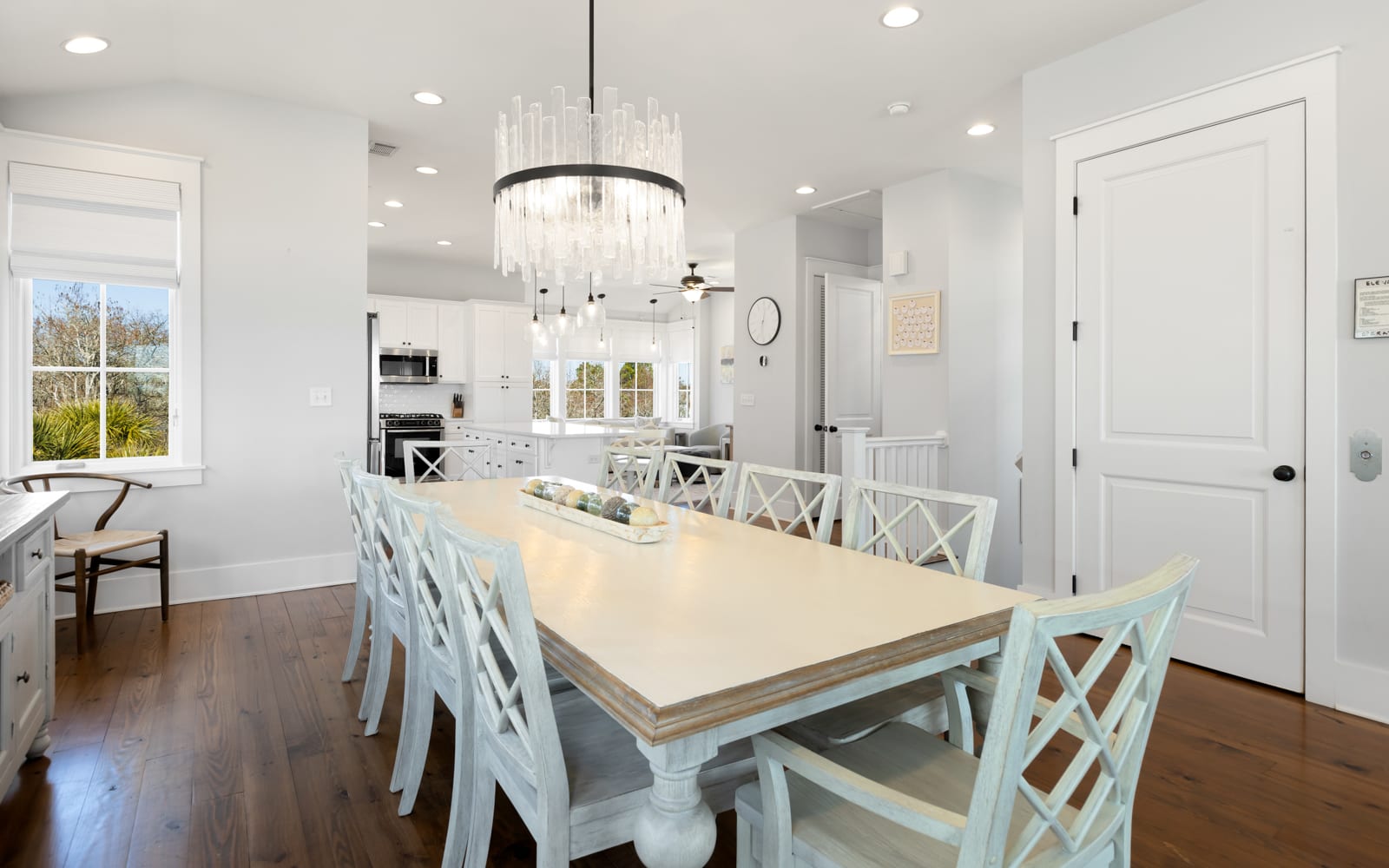 Gather around your elegant dining table for memorable meals beneath a stunning chandelier in this bright, open space.
