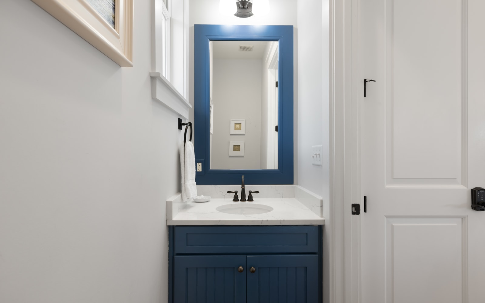 Step into your elegant powder room featuring a striking navy vanity and pristine marble countertop, perfectly designed for your comfort.