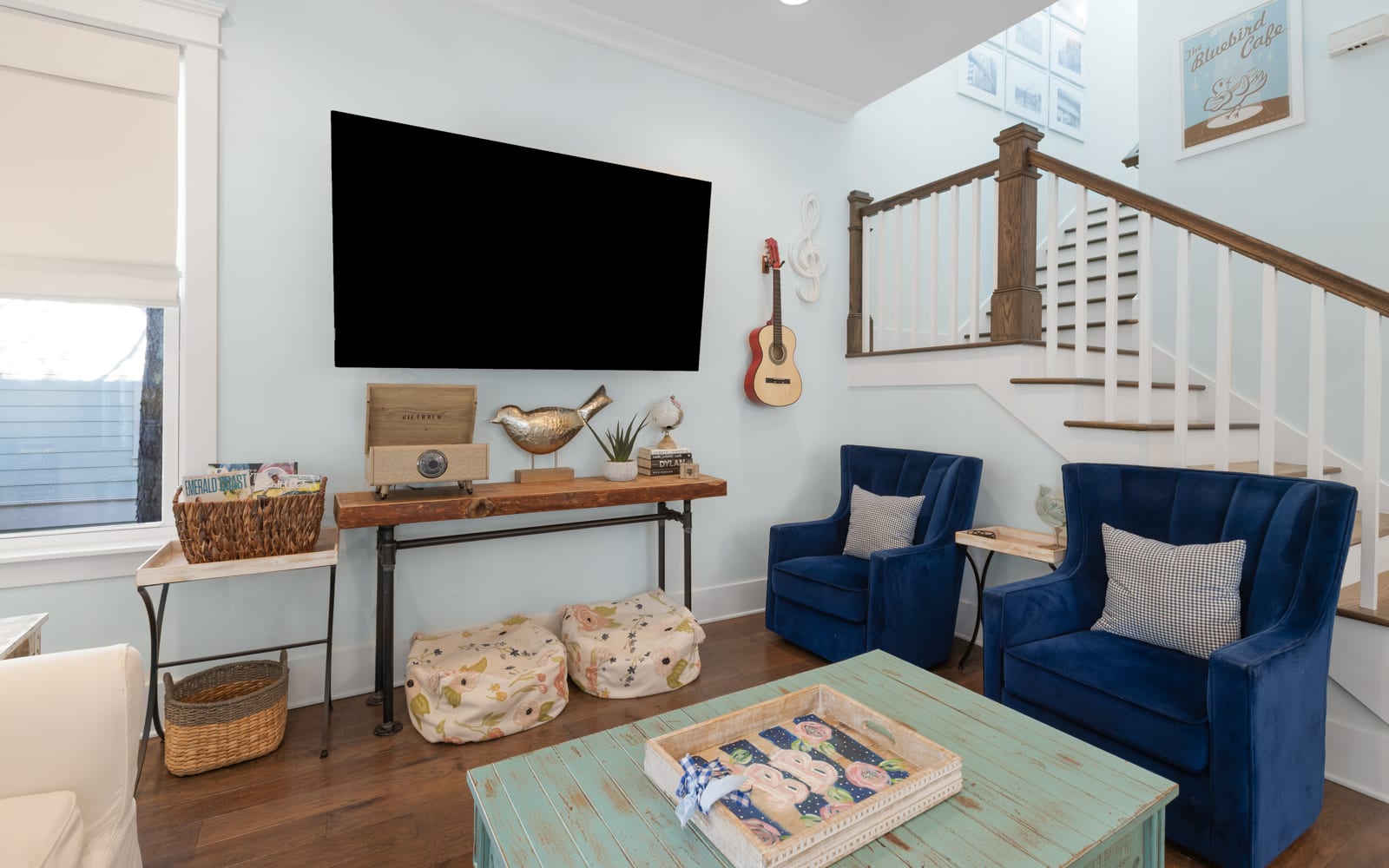 Relax in your charming living room where coastal blues meet warm wood tones, complete with entertainment and cozy seating.