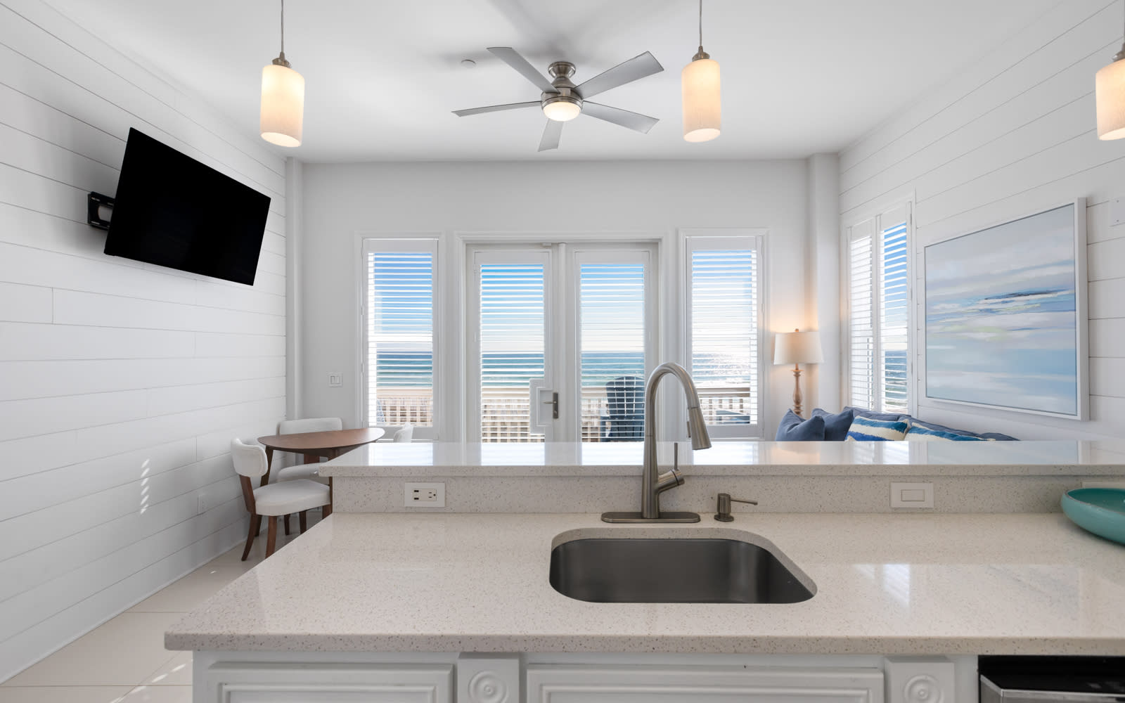 Your bright kitchen features sleek countertops and stunning ocean views through expansive windows, perfect for morning coffee with sea breezes.