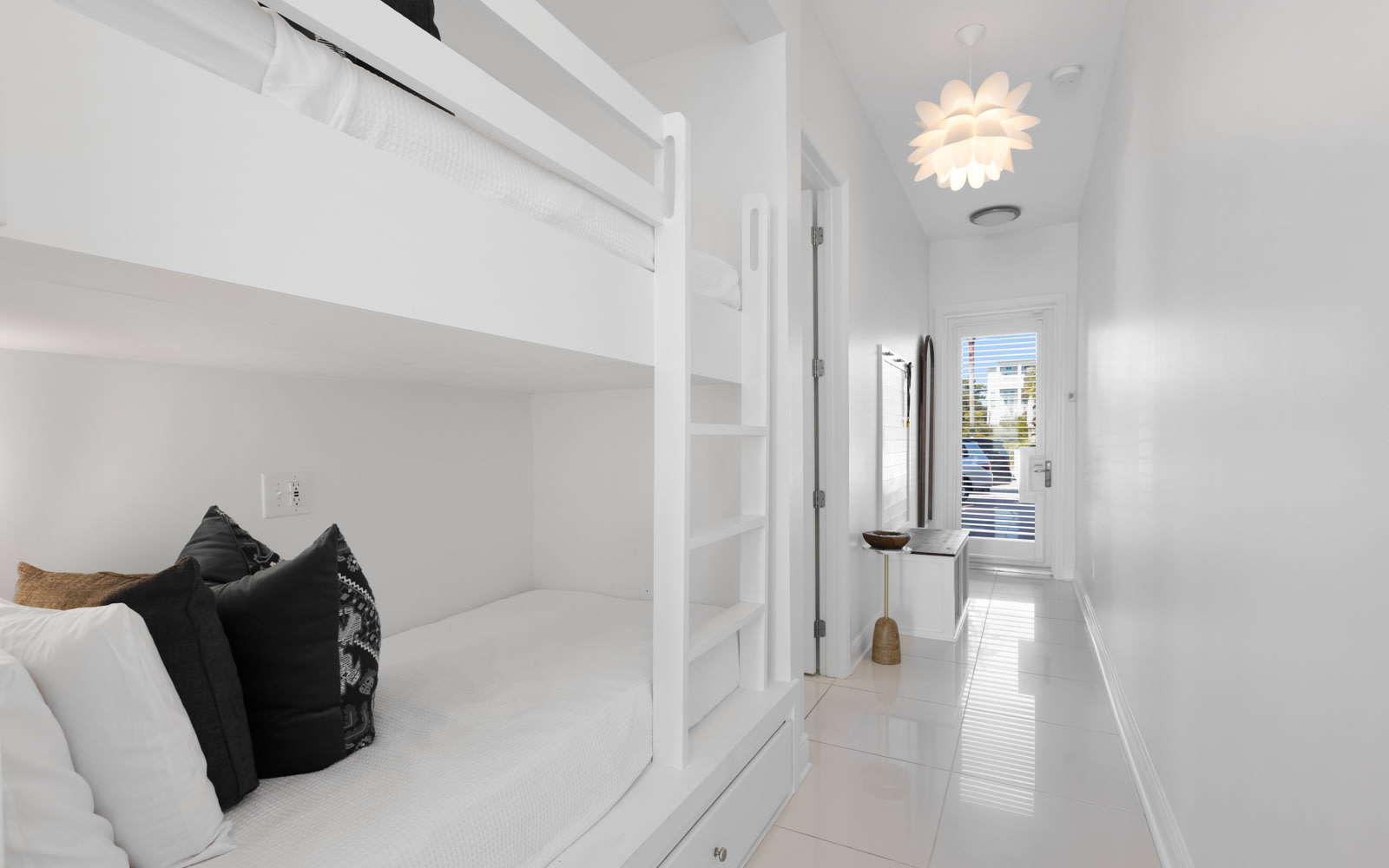 Drift off in this bright bedroom featuring custom bunk beds and stylish design touches that create a cozy retreat.