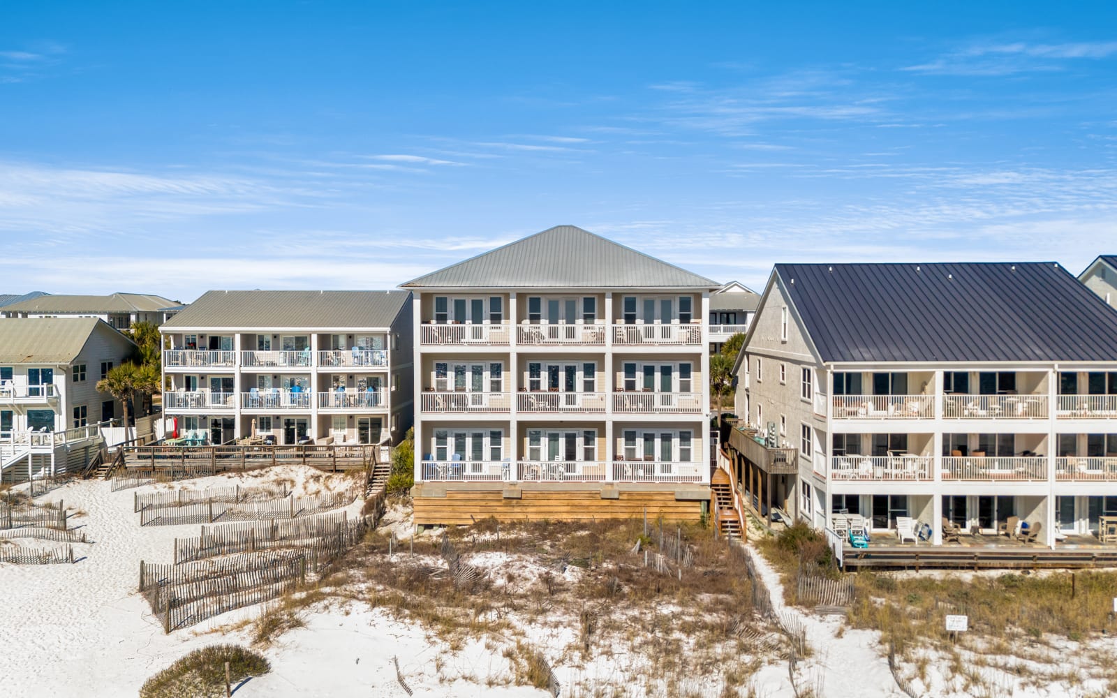 Beachfront rental complex featuring multiple vacation buildings with private balconies overlooking pristine white sand beaches.