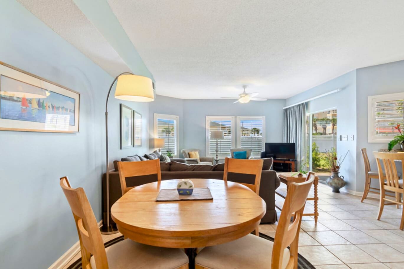 Your bright open-plan living space combines dining and relaxation perfectly, with soothing blue walls and warm wood touches creating a welcoming coastal vibe.