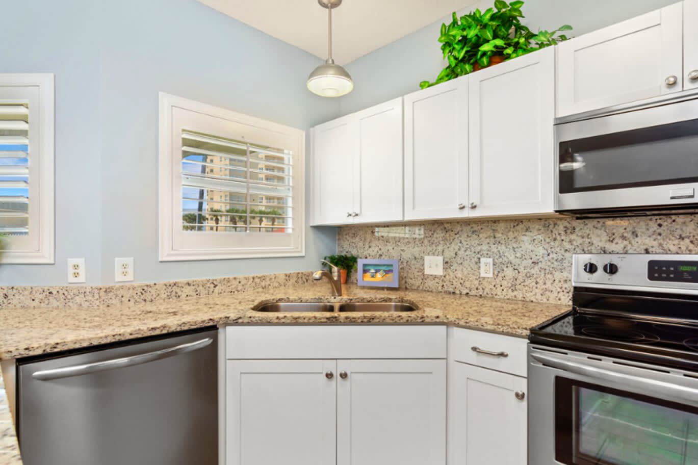Bright, coastal-style kitchen with granite countertops, white cabinetry, modern appliances, and a clean, open design that makes cooking and gathering easy and enjoyable.