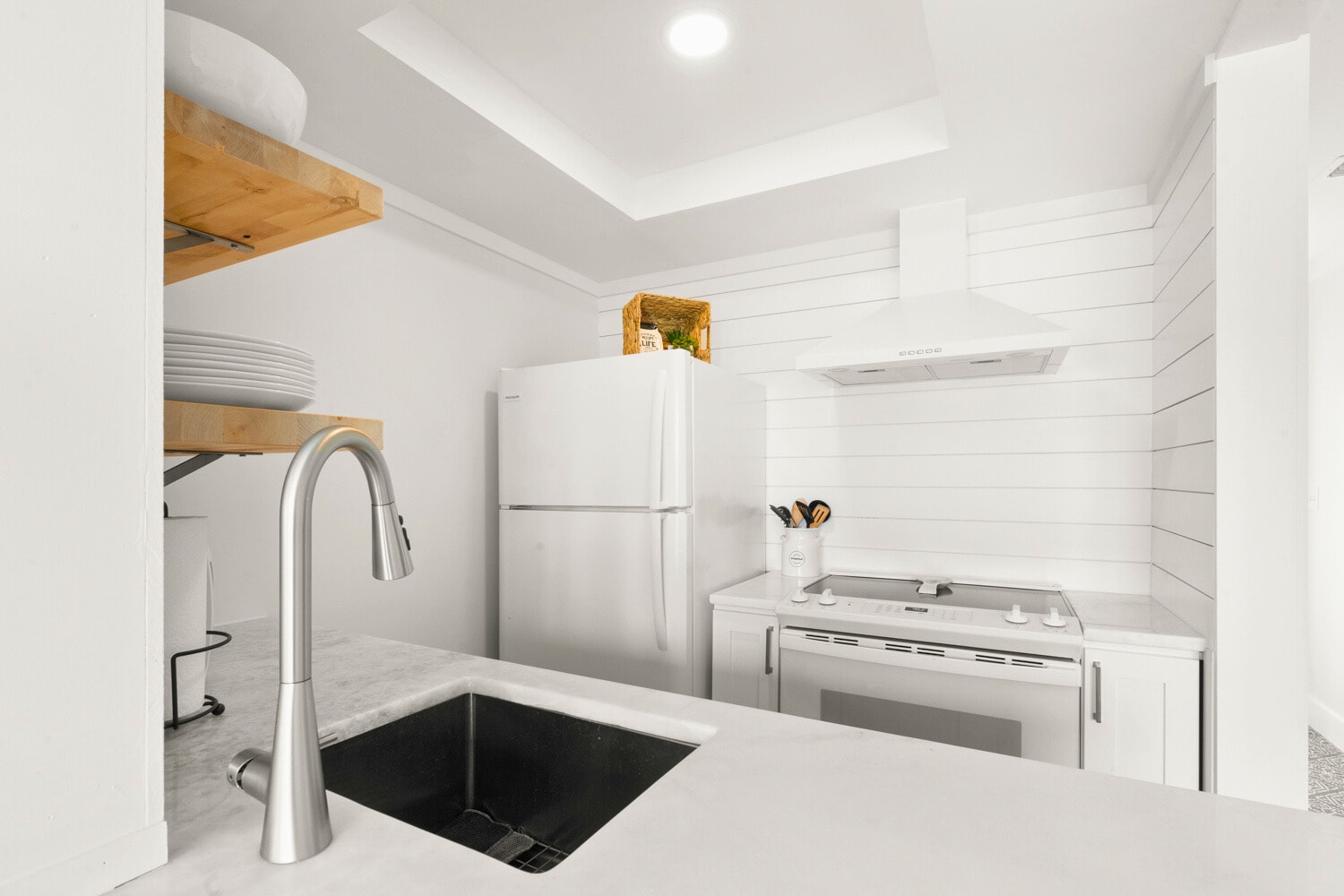 Your bright kitchen features sleek counters, modern appliances, and open shelving for easy meal prep during your stay.