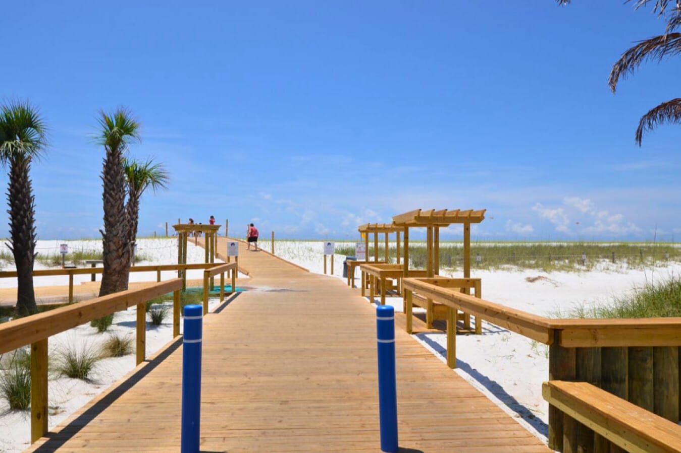 Wooden boardwalk leading to a private, sugar-white sand beach with shaded pavilions and sweeping Gulf views—an inviting path to relaxing beach days and unforgettable Emerald Coast sunsets.