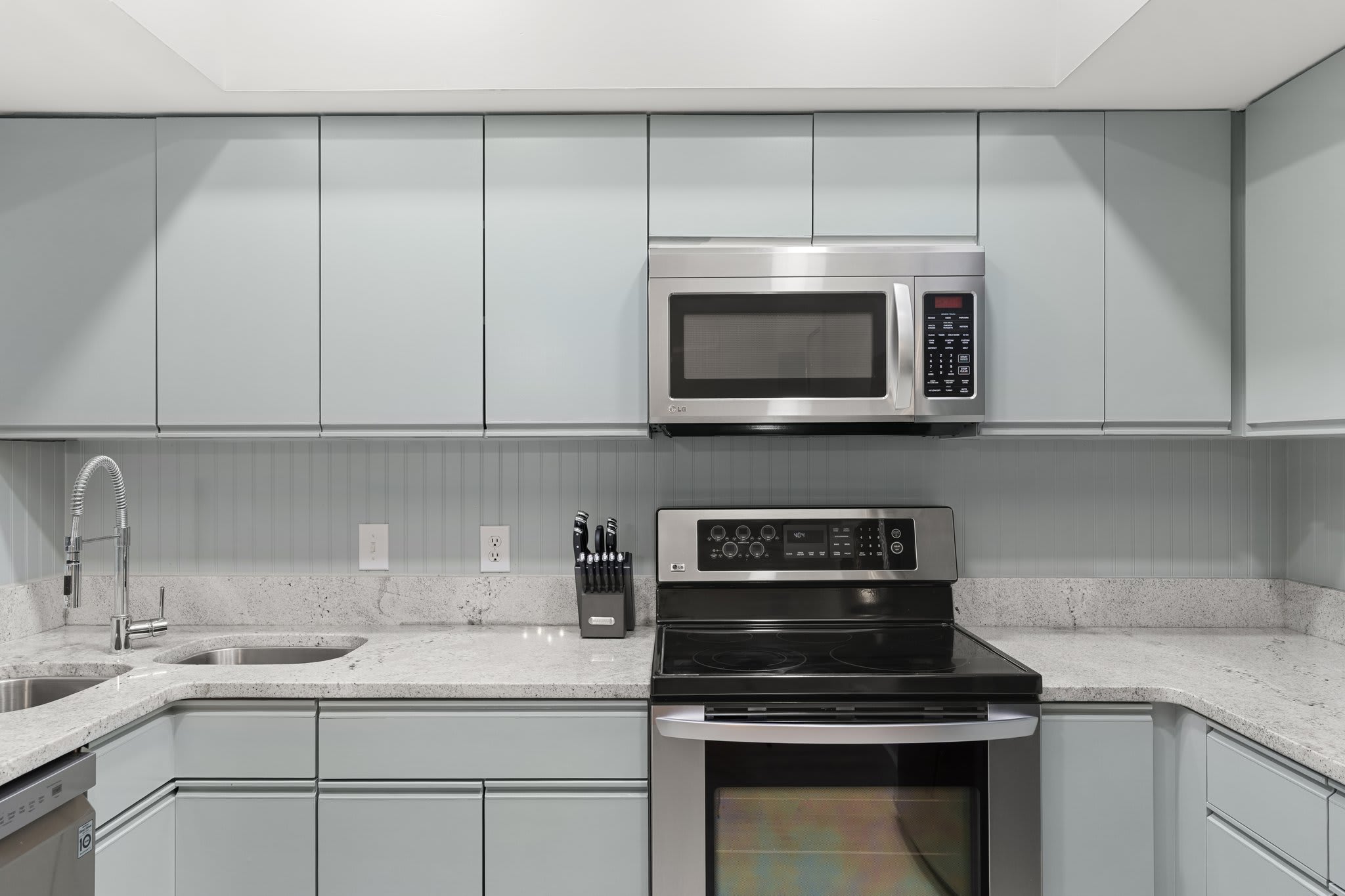Sleek and functional, this kitchen boasts wood cabinetry, granite counters, and stainless-steel appliances.