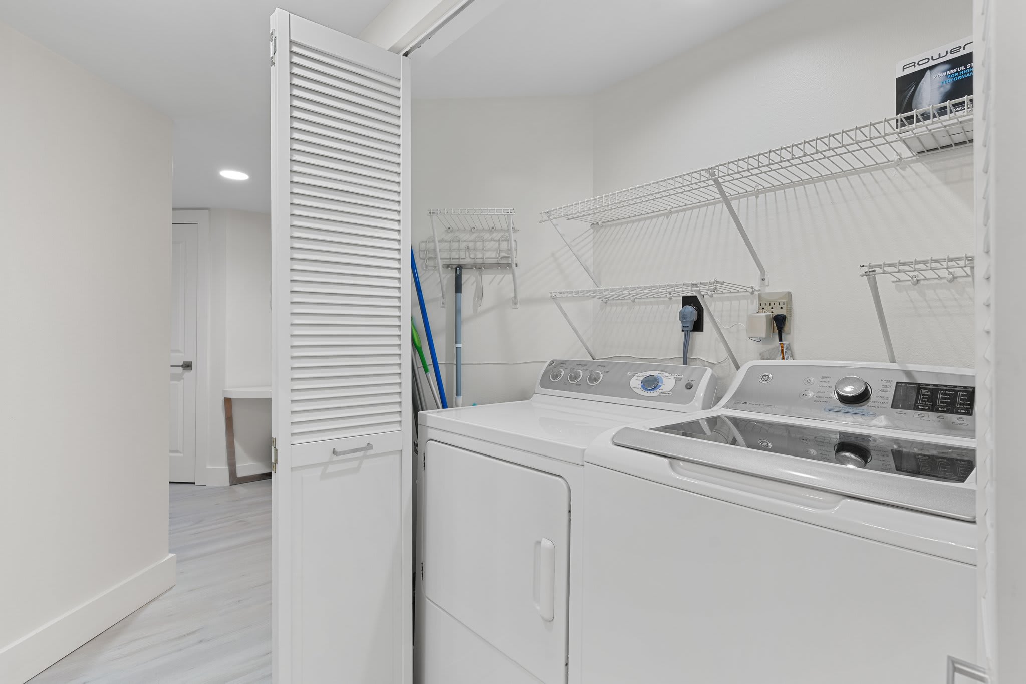 Tucked behind louvered doors, this laundry nook offers a full-size washer and dryer for added convenience.