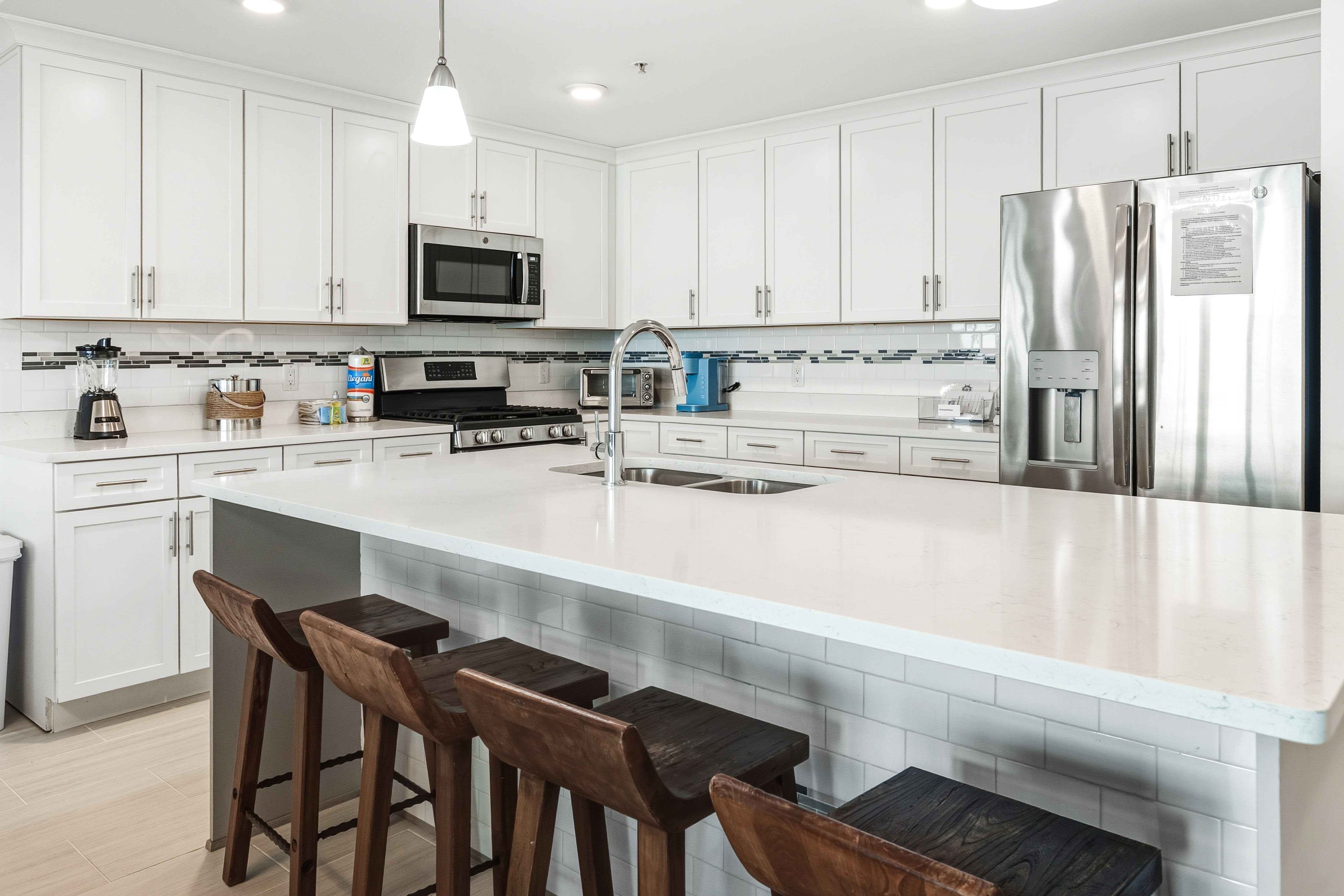 Your spacious kitchen features sleek white cabinetry, quartz countertops, and stainless steel appliances—perfect for preparing memorable meals together.