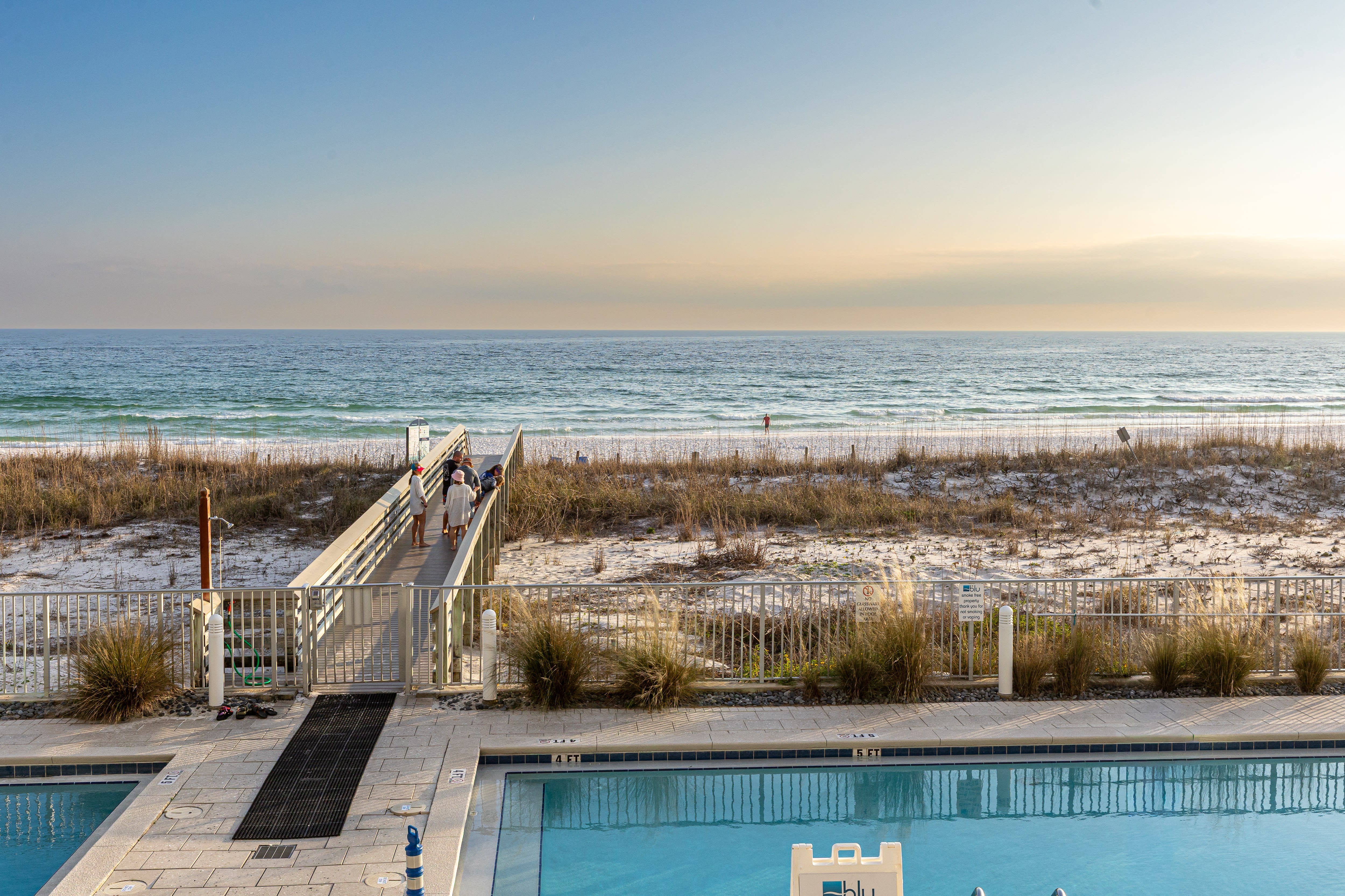 Beachfront pool with direct access to pristine white sand beach and emerald waters.