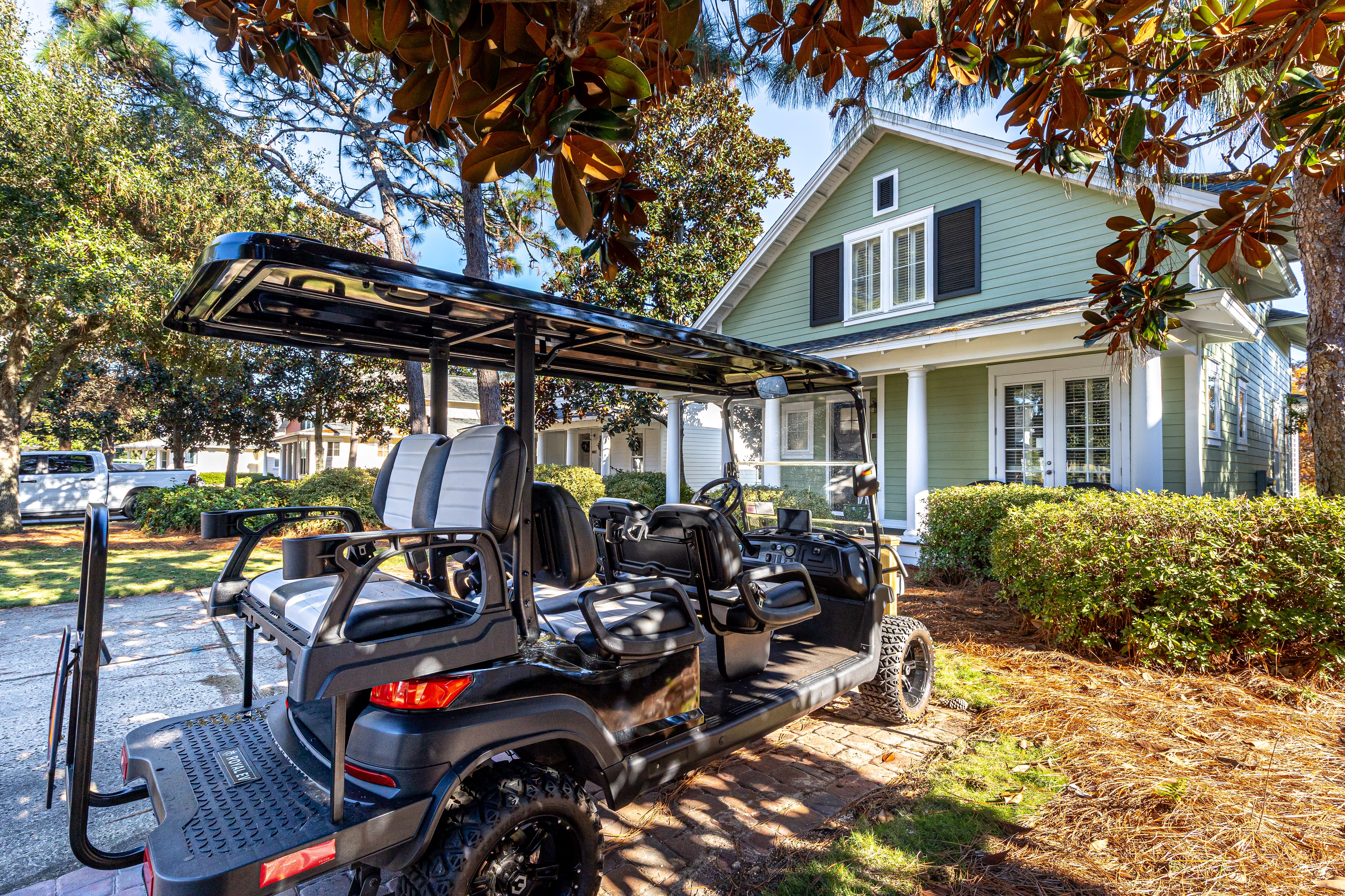 Charming mint green property with convenient golf cart access for easy exploration of the surrounding tree-lined neighborhood.
