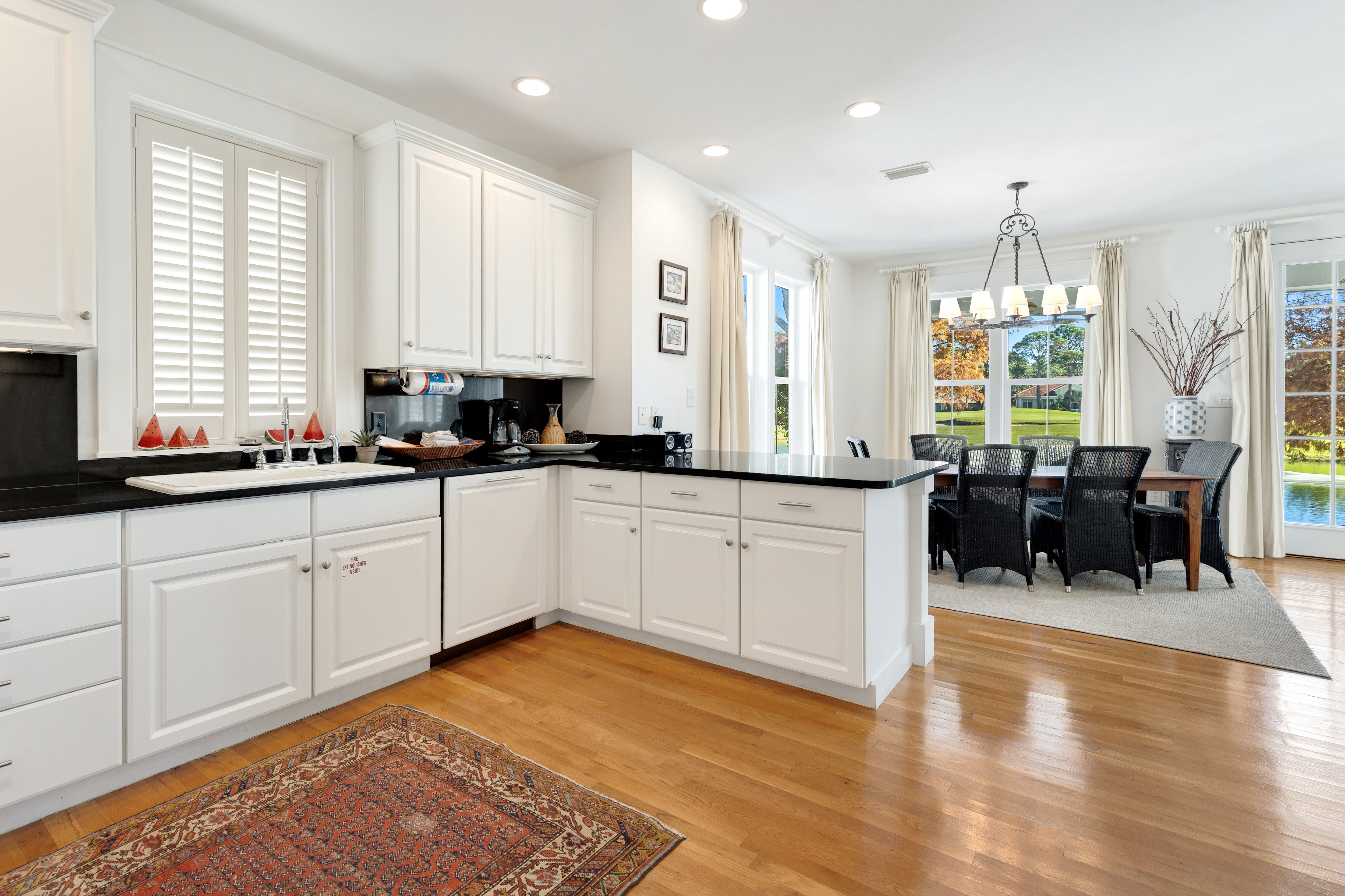 Cook your favorite meals in this bright, modern kitchen with white cabinets and dark countertops, then enjoy dining with lake views.