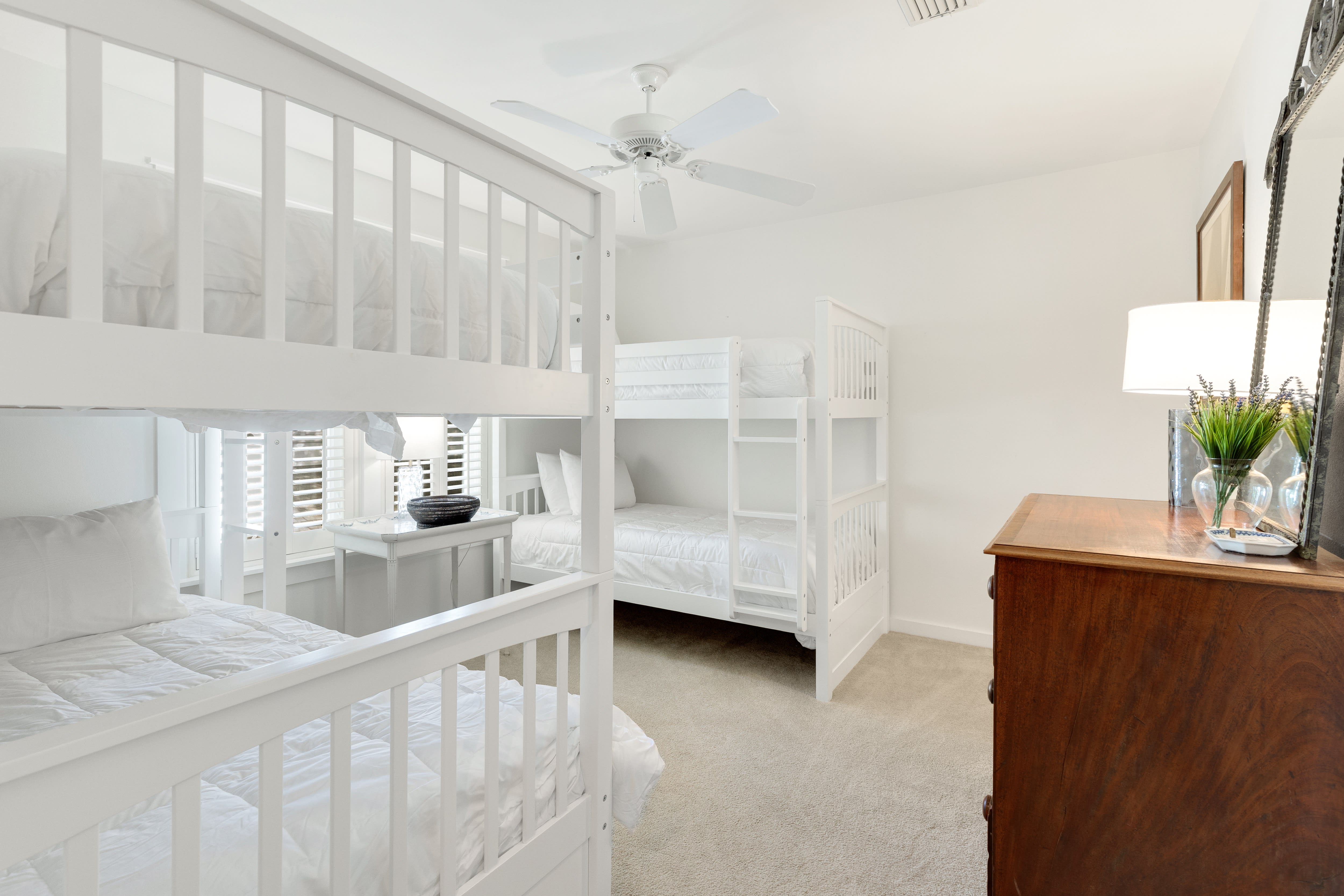 Your family will love this bright bunk room with crisp white beds, soft carpeting, and thoughtful touches like fresh greenery.
