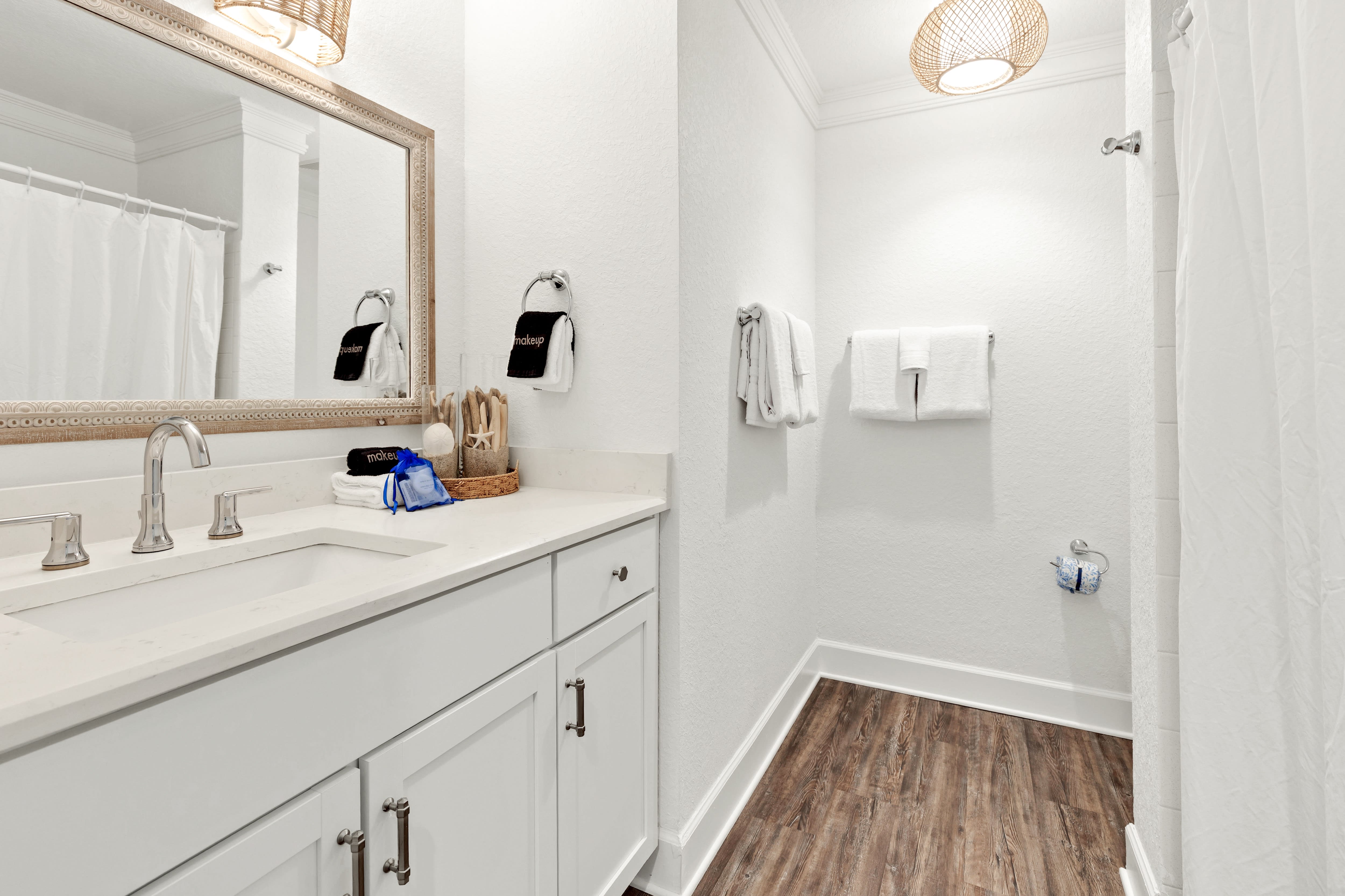 Your bright, spa-like bathroom features marble tile, a rainfall shower, and woven pendant lighting for ultimate relaxation.