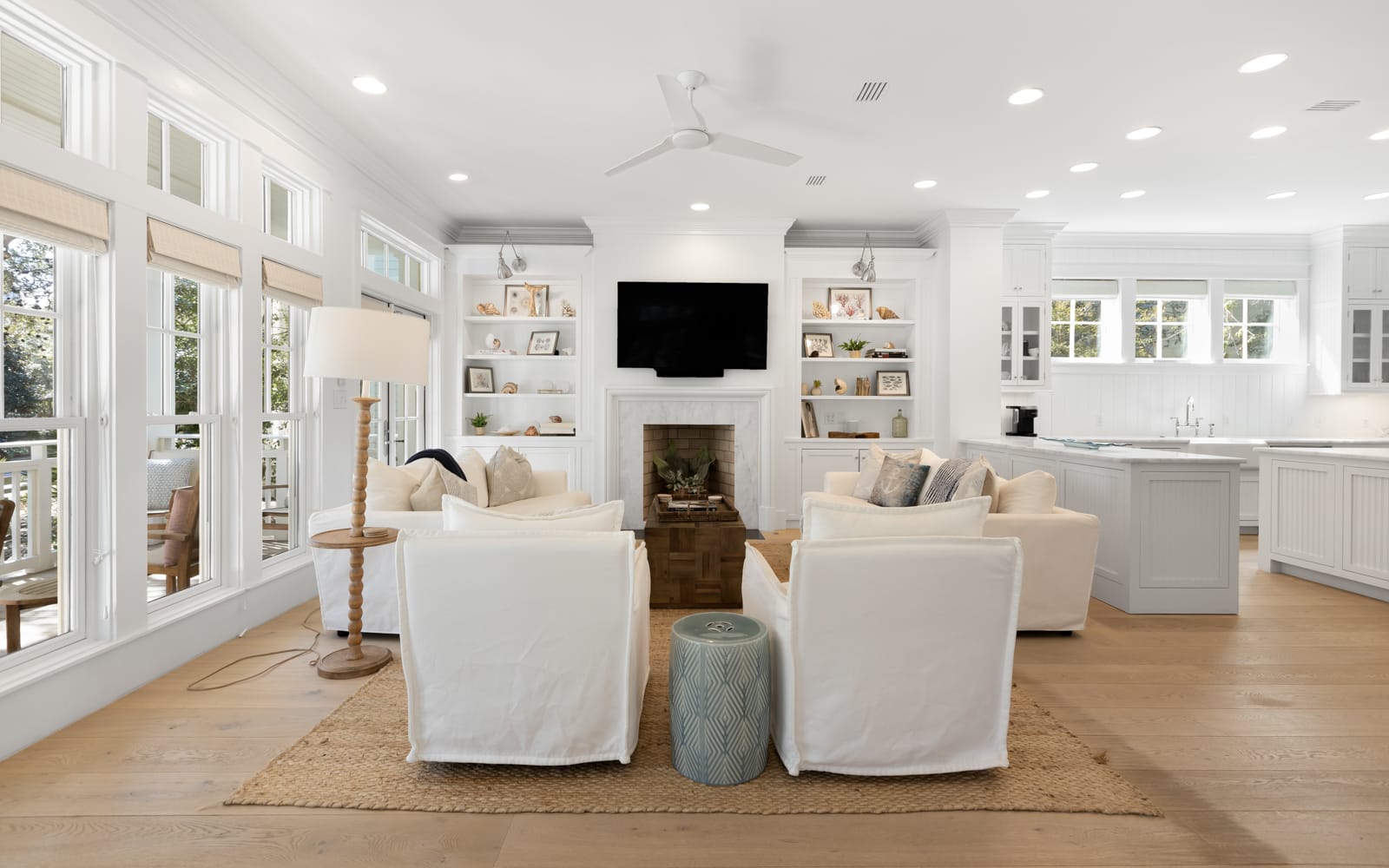 Sink into plush white seating while you watch your favorite shows by the fireplace in this bright, airy living space.