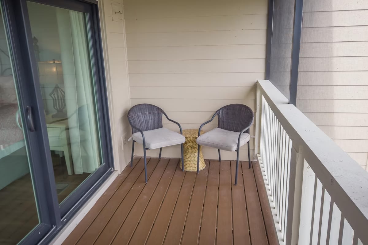 Cozy balcony nook with cushioned chairs and a side table—an ideal spot for quiet mornings, reading, or unwinding after a beach day.