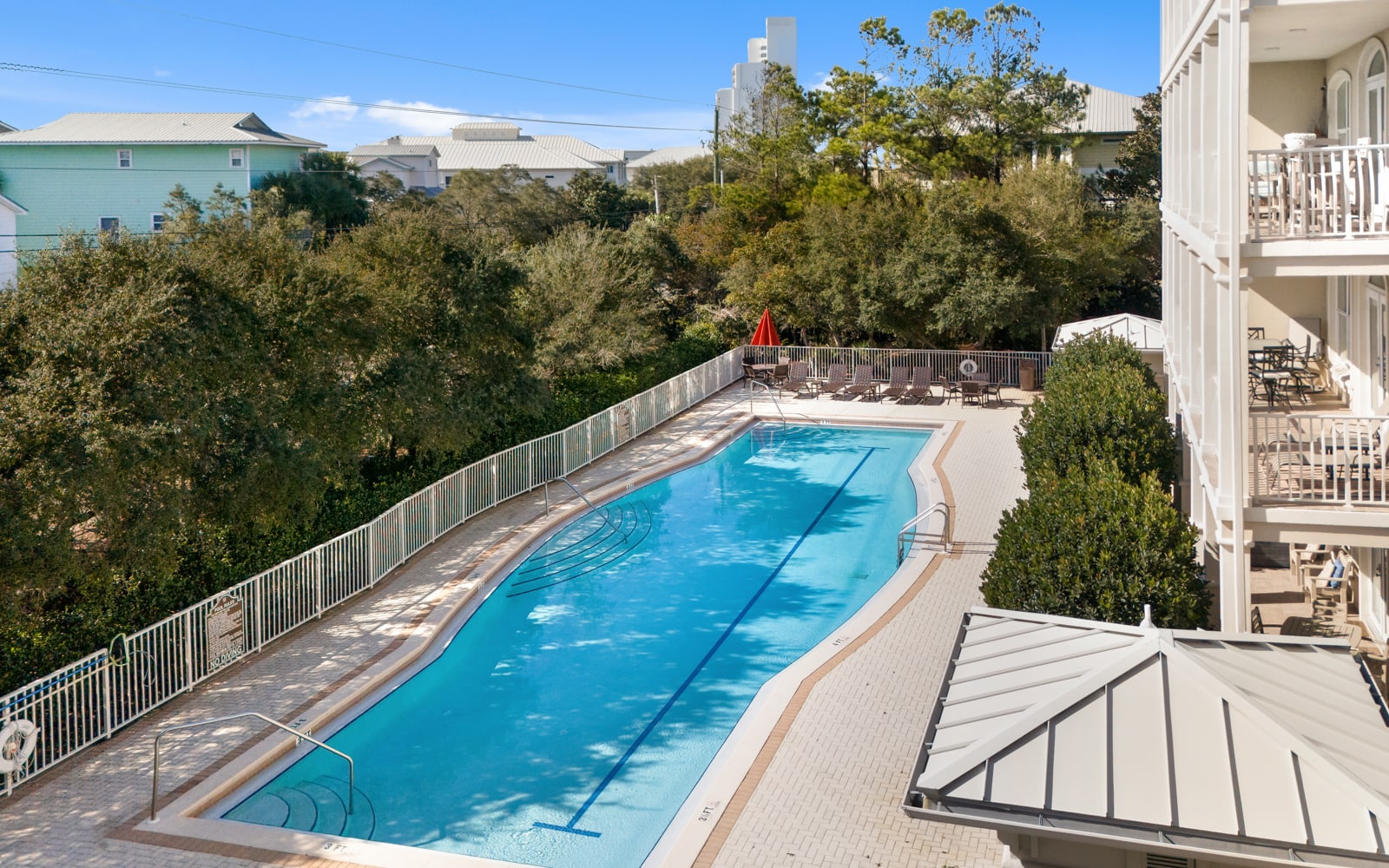 Sparkling blue pool surrounded by lush greenery, perfect for your morning swim or afternoon relaxation.