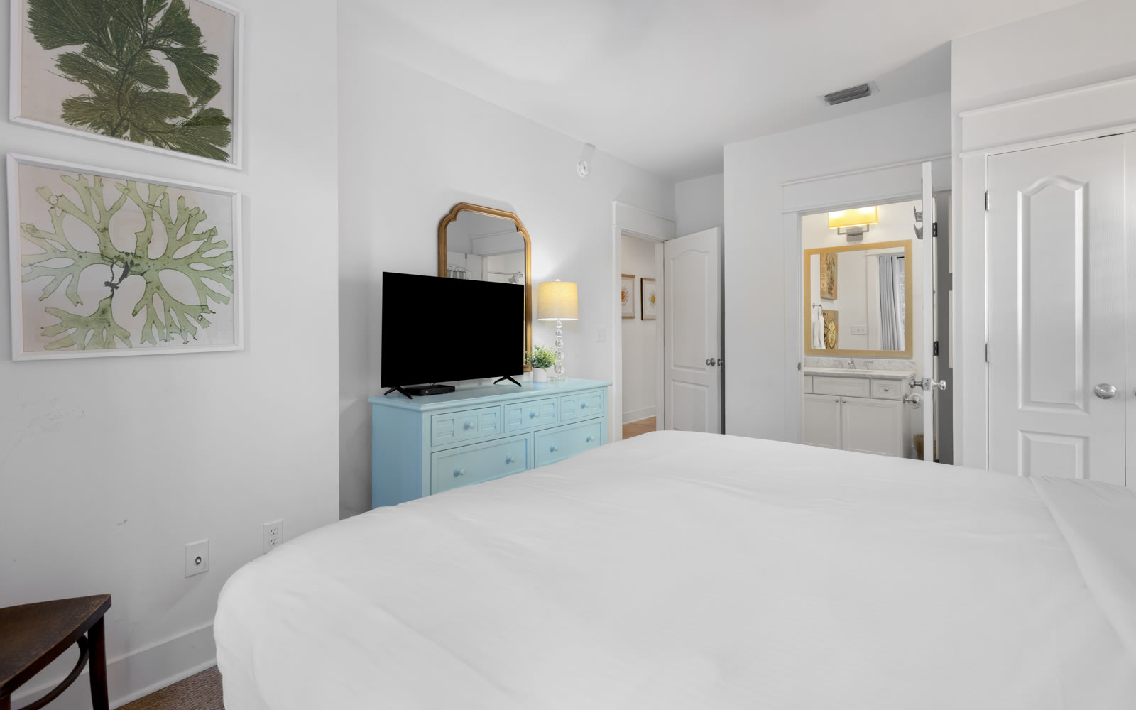 Drift into peaceful sleep in your serene bedroom, featuring crisp white linens, charming coastal decor, and your own ensuite bathroom for ultimate comfort.
