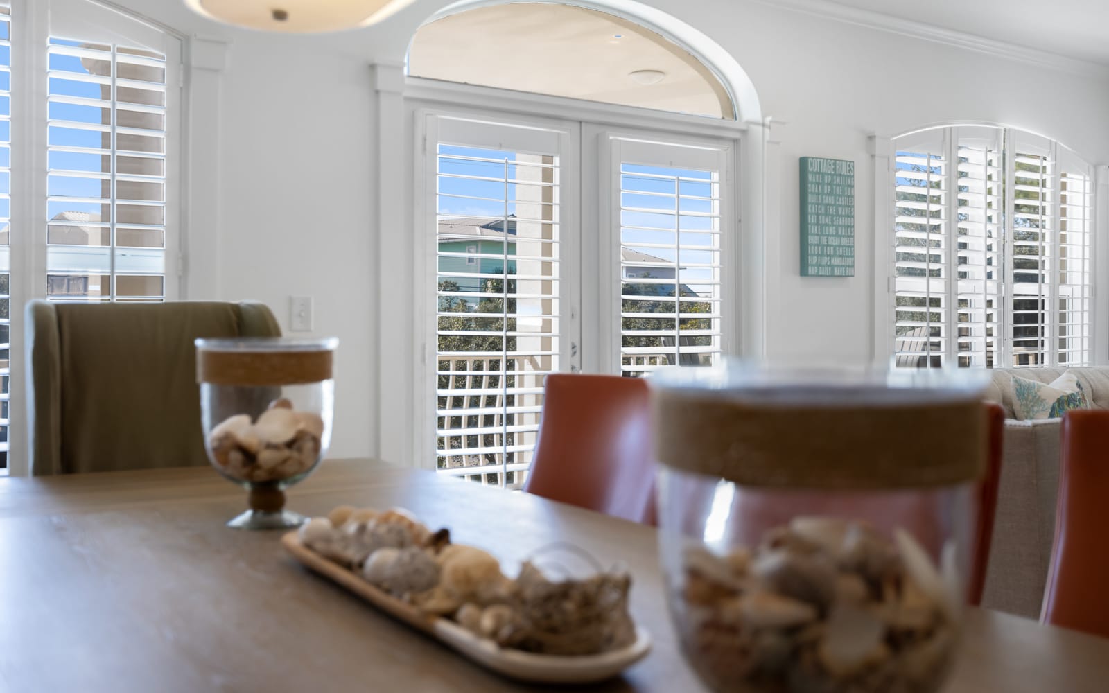 Relax in your bright dining space with elegant arched windows and plantation shutters filtering natural light beautifully.