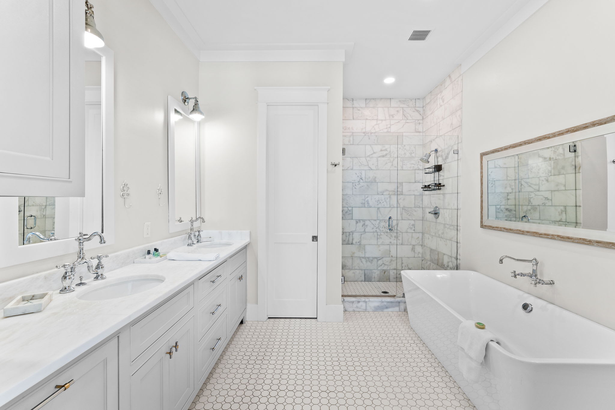 Primary en-suite featuring dual vanities, soaking tub, and walk-in shower for a luxury retreat.