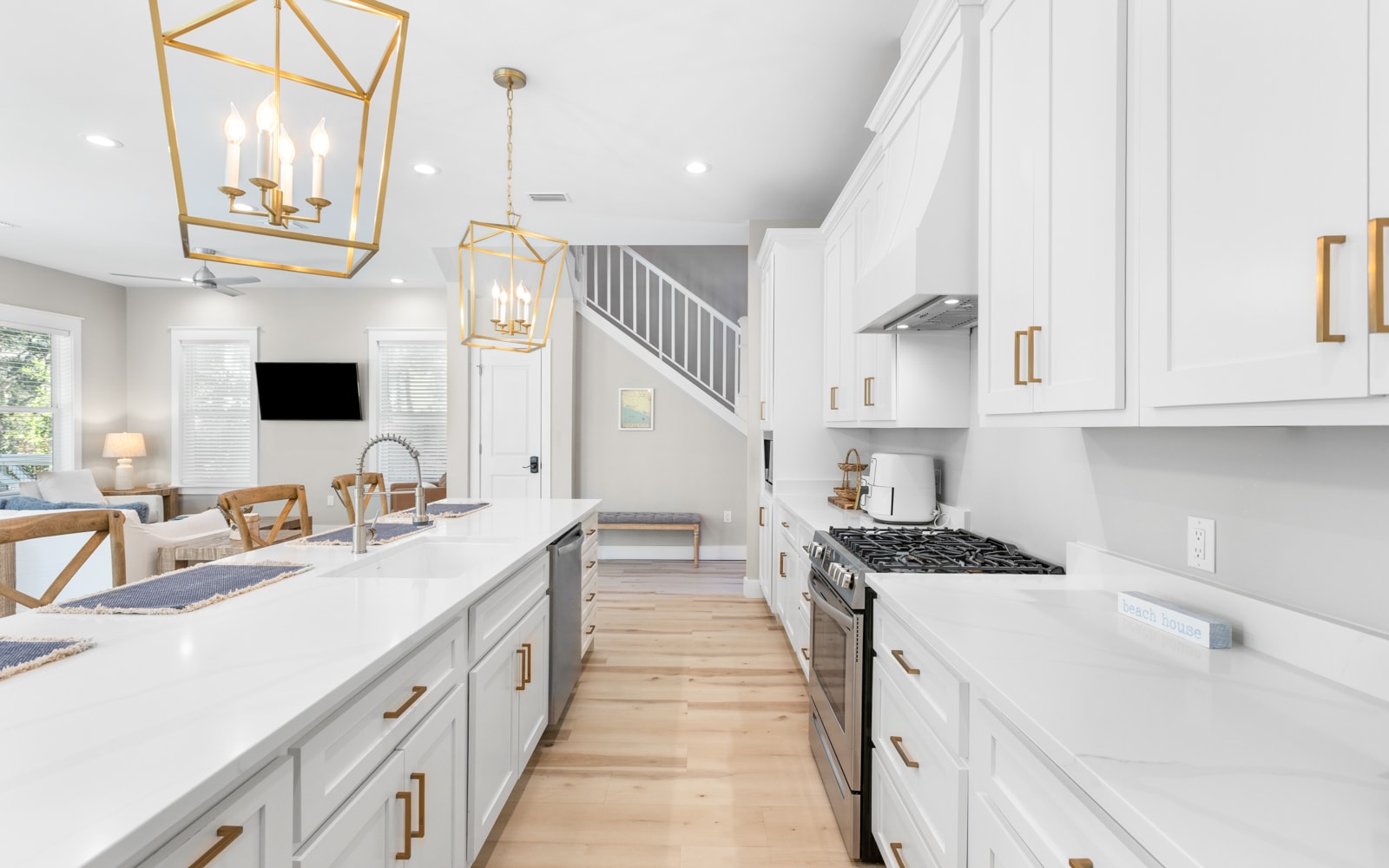 Your gourmet kitchen awaits with sleek white cabinets, gleaming countertops, and stylish brass fixtures that catch the light beautifully.