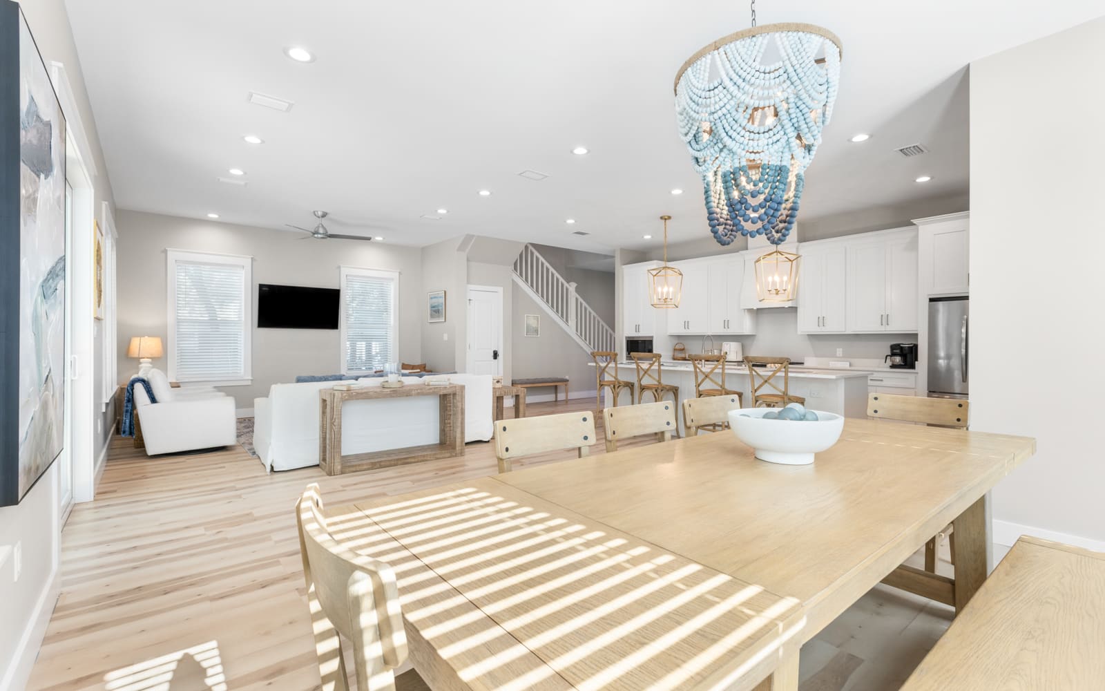 Unwind in your bright, open-concept space where coastal elegance meets comfort with designer lighting and natural wood warmth.