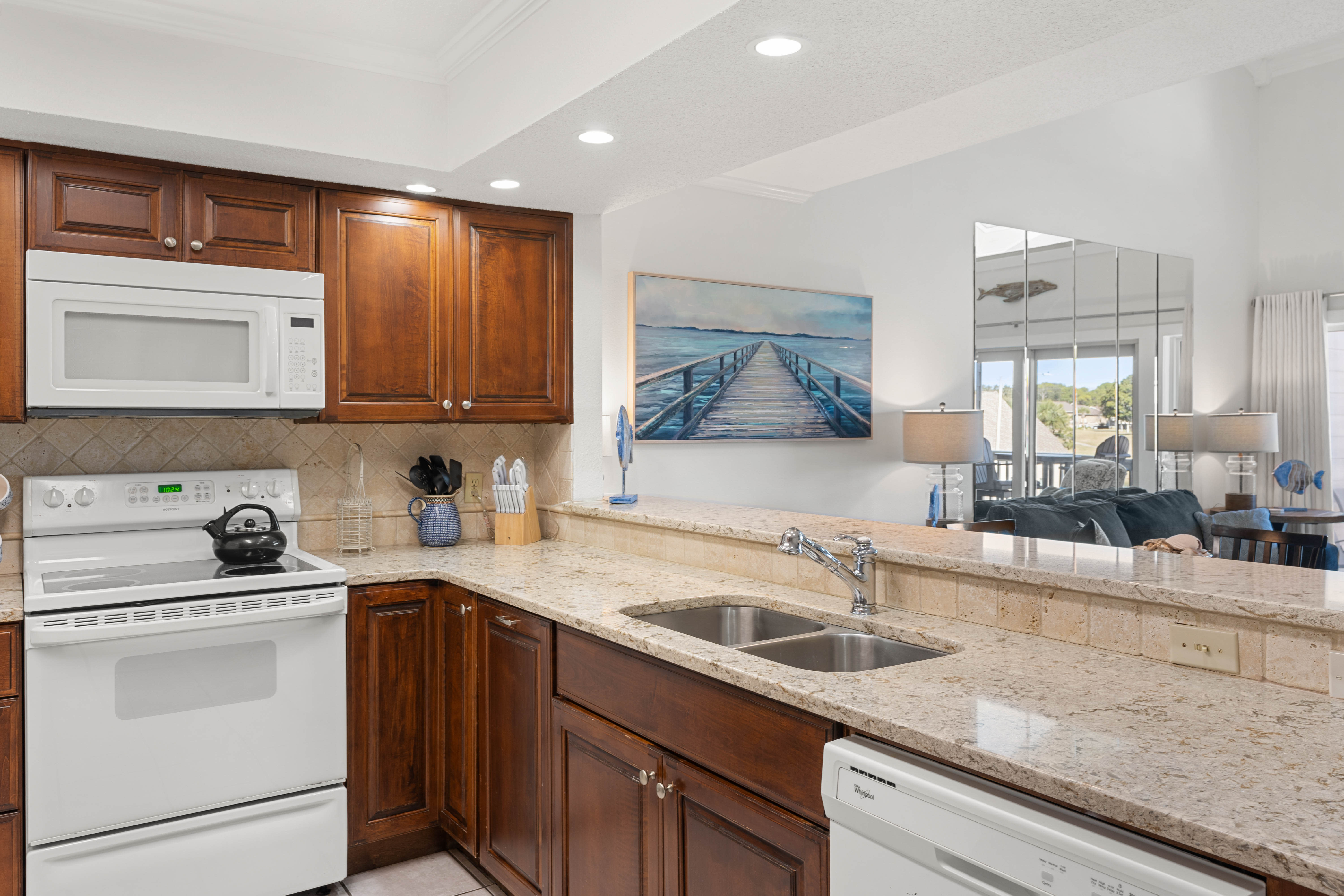 Your fully-equipped kitchen features granite countertops, rich wood cabinets, and stainless steel appliances, perfect for preparing meals while enjoying the open living space.