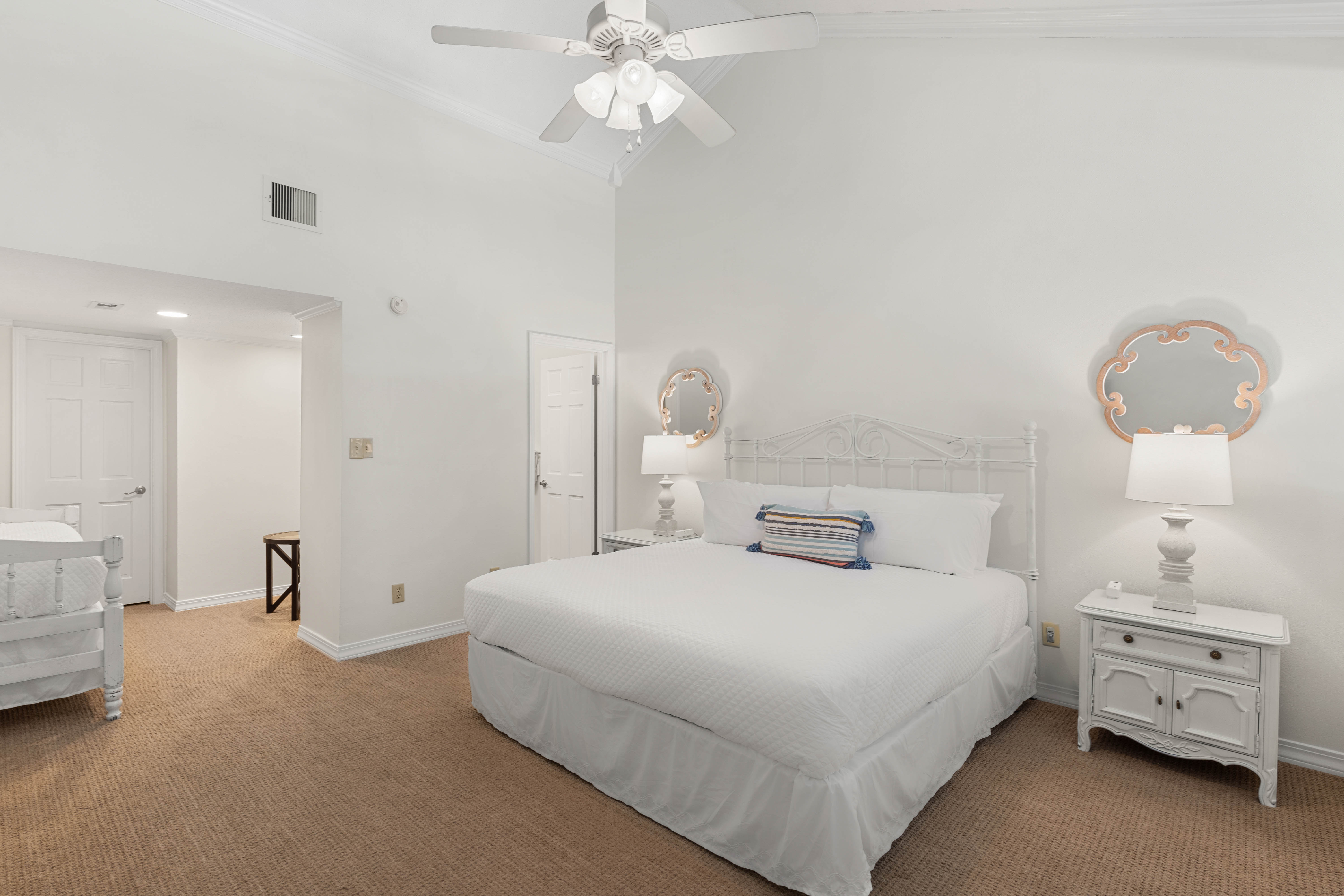 Rest peacefully in your bright bedroom featuring a plush queen bed, charming coastal decor, and convenient en-suite access.