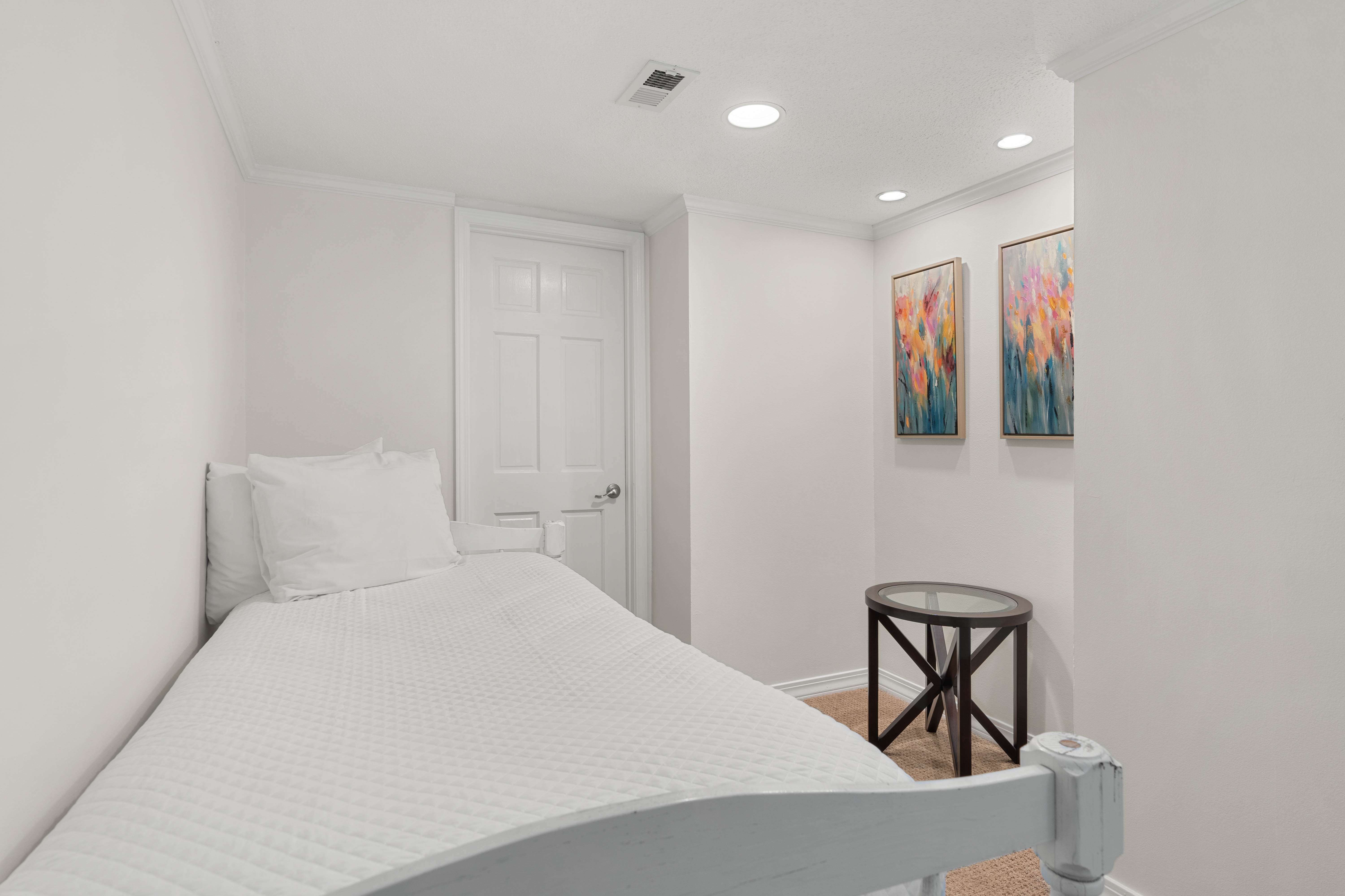 Rest peacefully in your cozy bedroom featuring crisp white linens, vibrant artwork, and thoughtful touches that make this space feel like home.