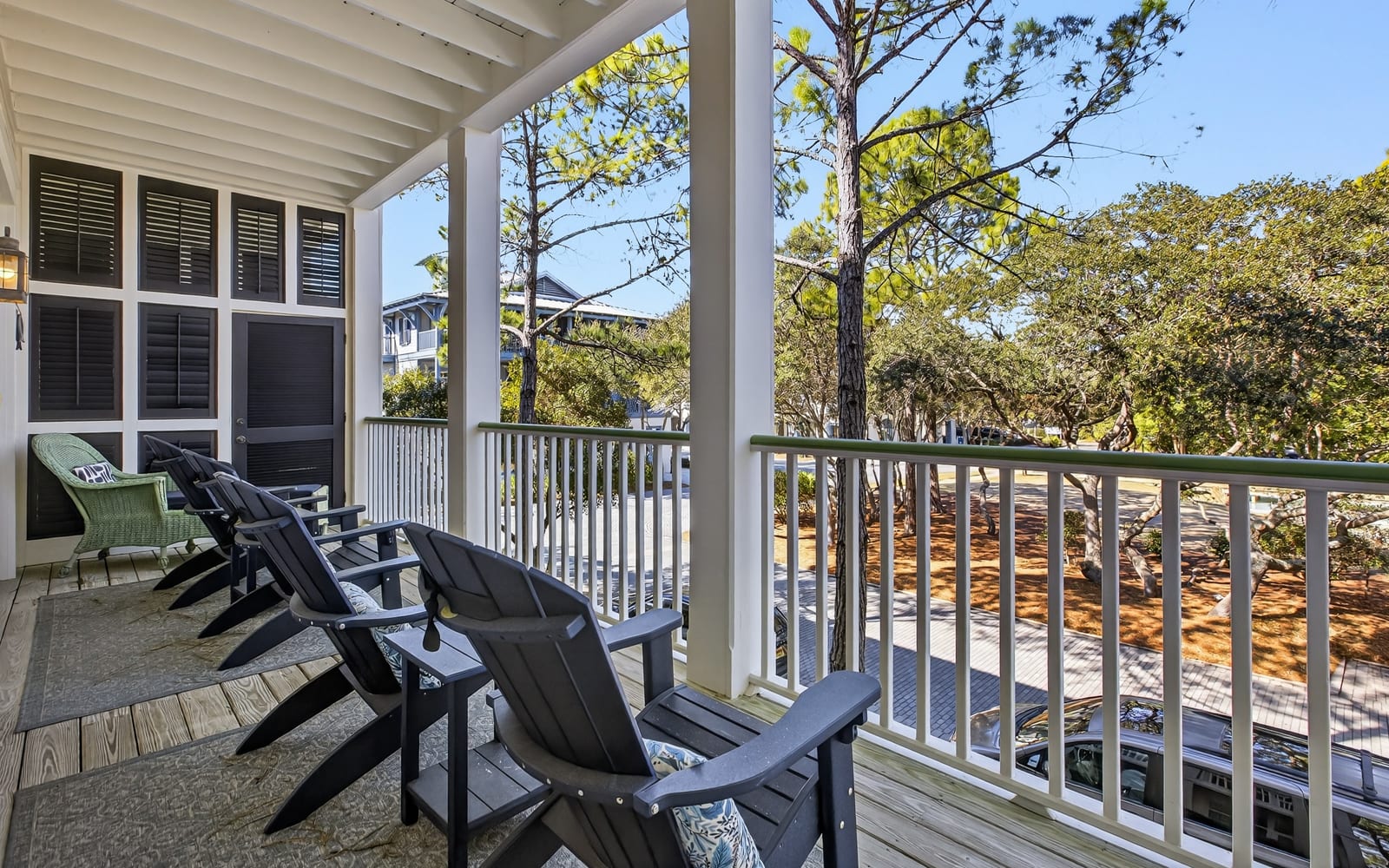 Relax on your private covered porch with comfortable Adirondack chairs, overlooking peaceful wooded surroundings perfect for morning coffee.