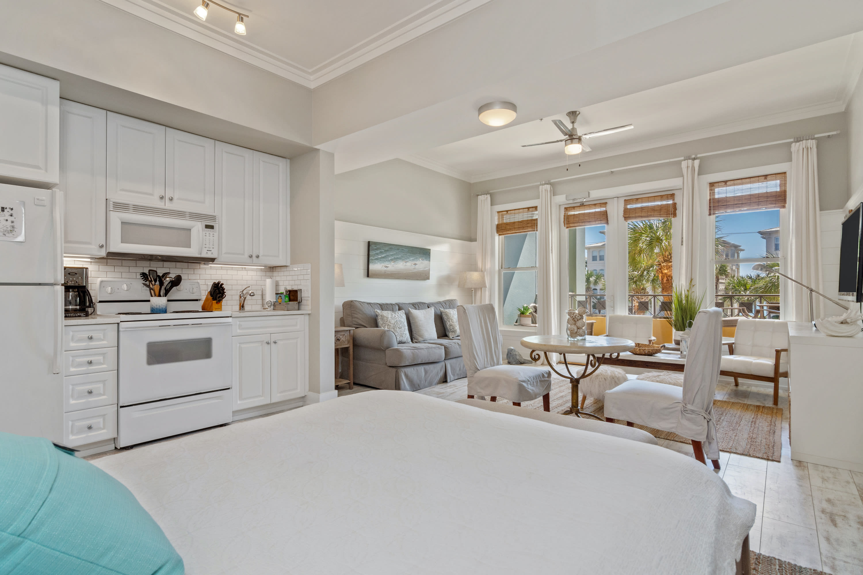 Bright and inviting 30A studio with a full kitchen, plush queen bed, and cozy living space. Floor-to-ceiling windows fill the room with natural light, creating a perfect coastal escape.