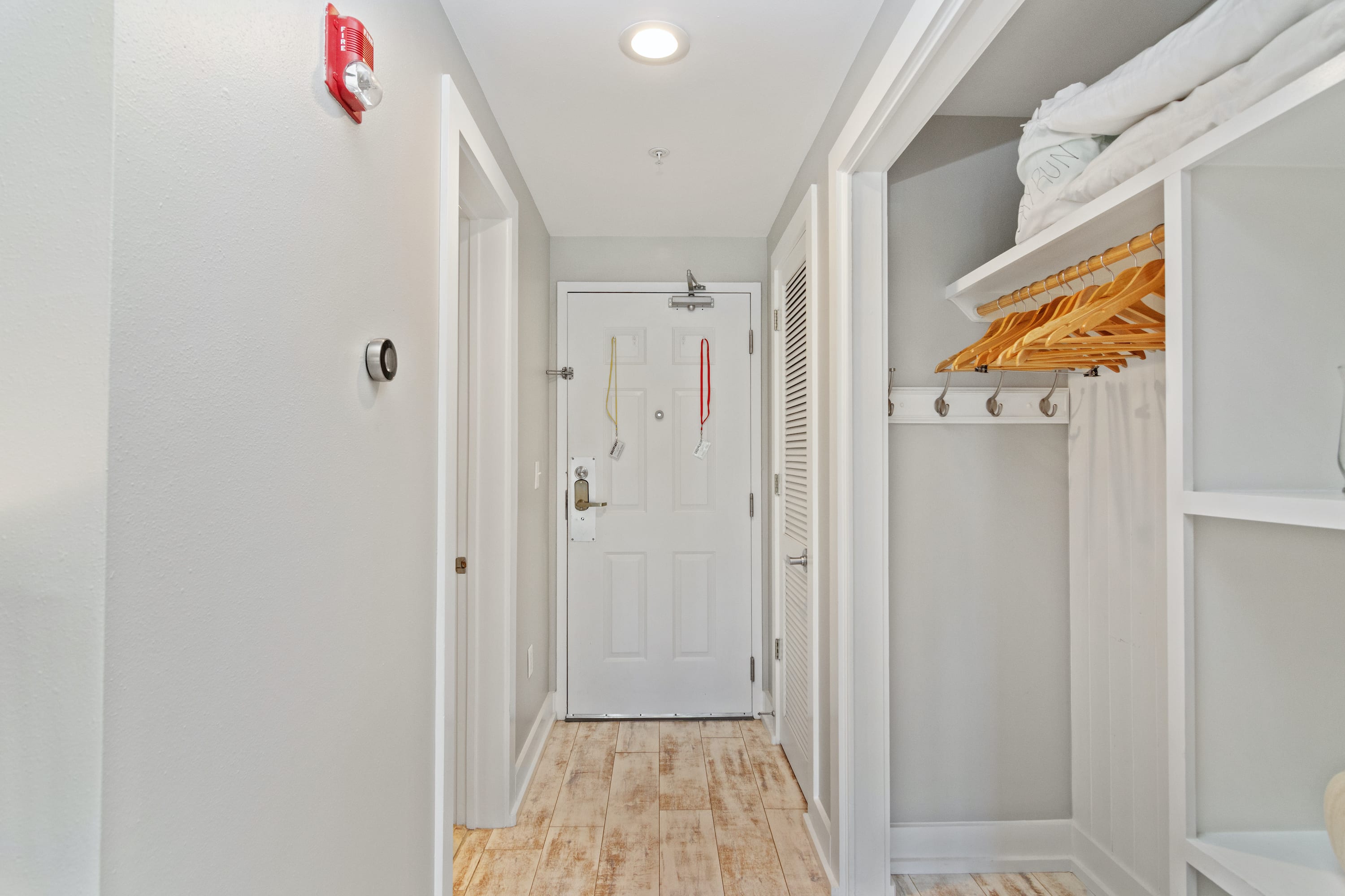 Welcoming entryway with coastal tones, wood-style floors, and a convenient open closet—setting the stage for your relaxing 30A beach stay.
