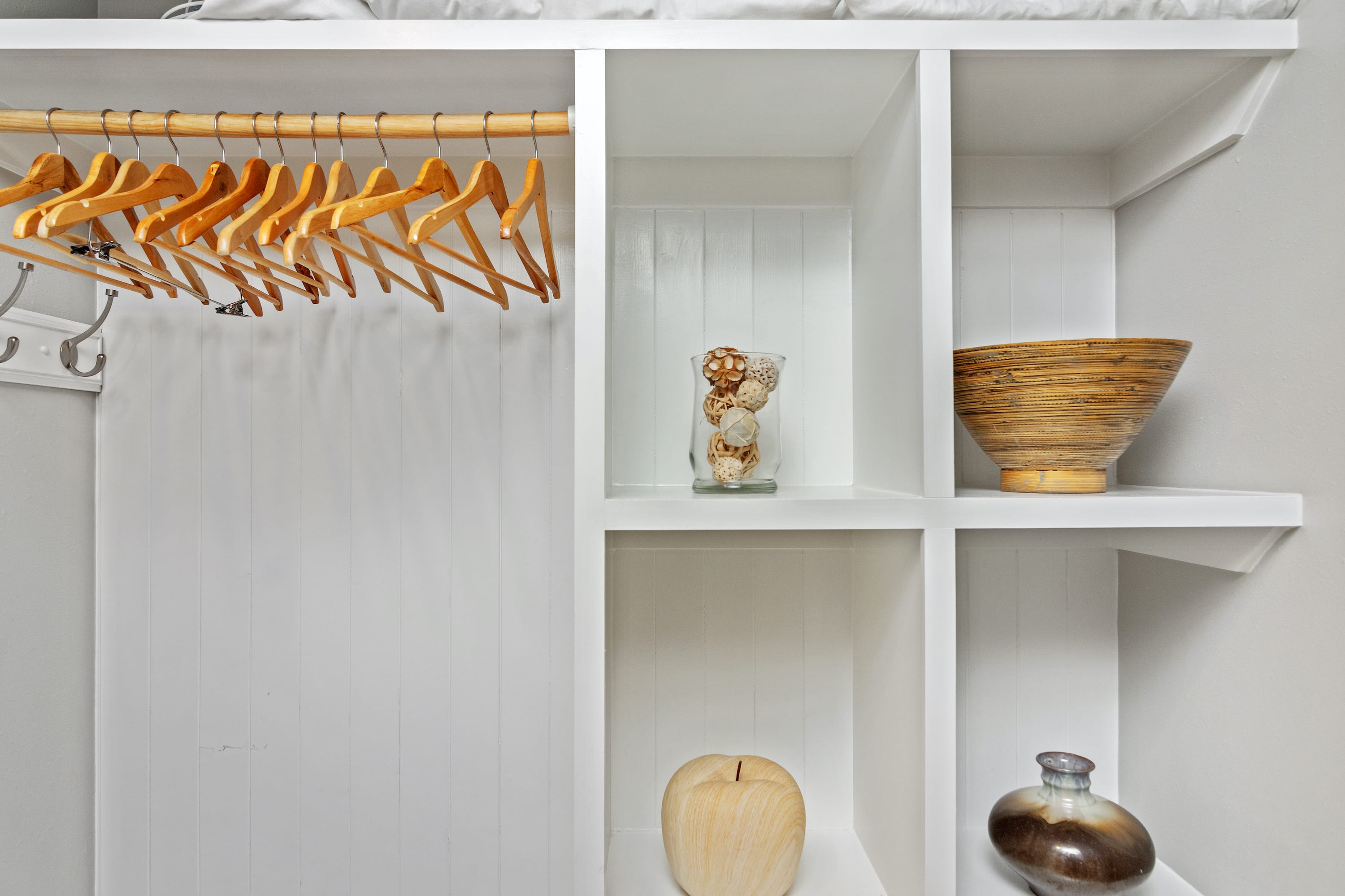 Thoughtfully designed open closet with wooden hangers and decorative shelving—offering both style and storage for your 30A vacation essentials.