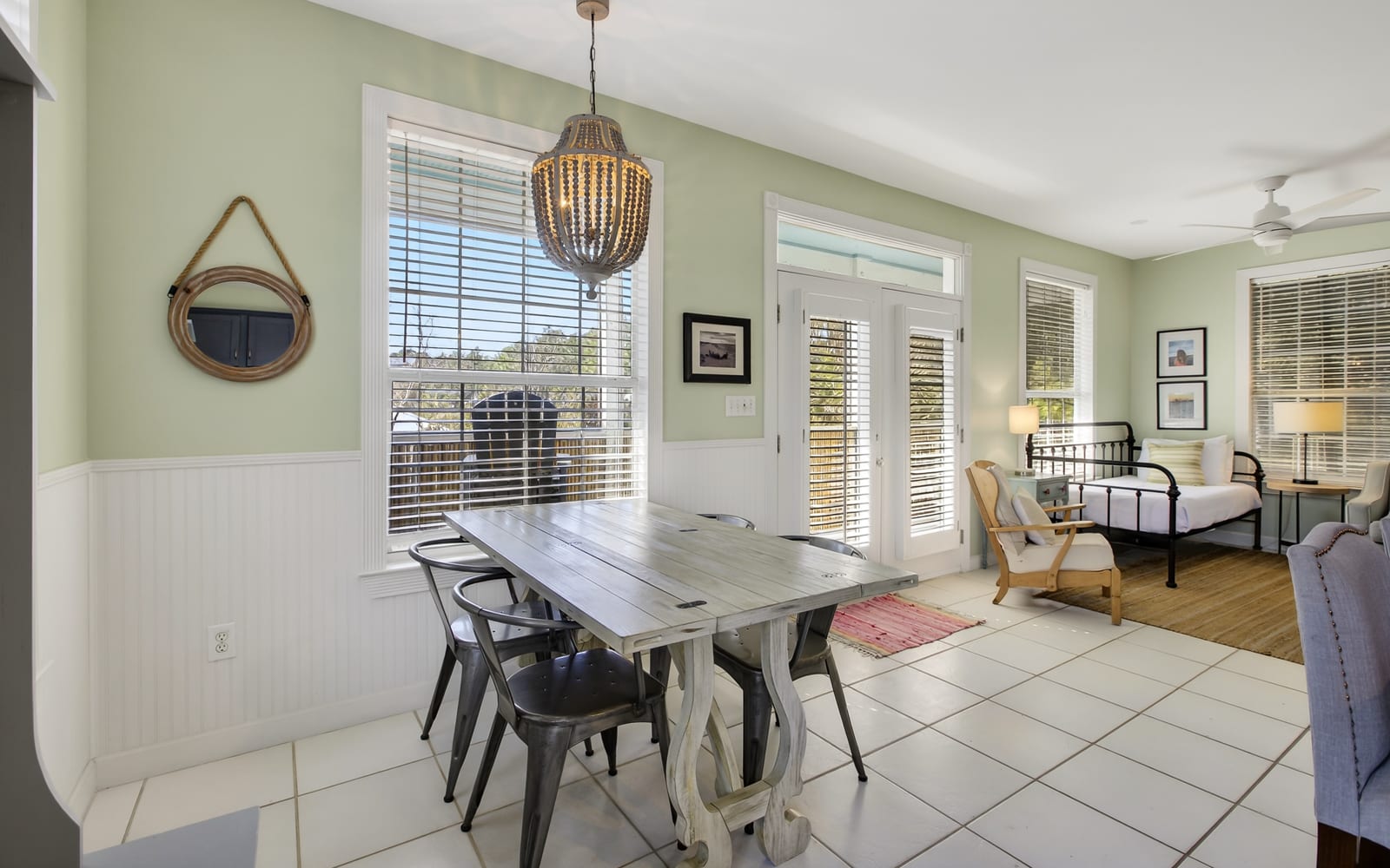 Gather around this rustic dining table where memories are made, with natural light streaming through French doors.
