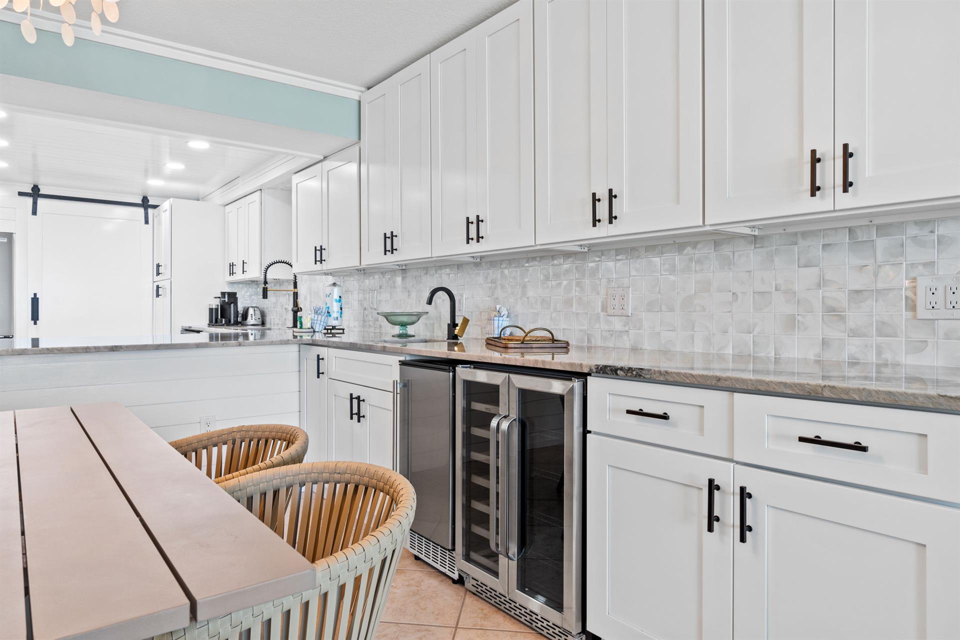 Step into your fully equipped kitchen with sleek white cabinetry, granite counters, and modern appliances perfect for preparing memorable meals together.