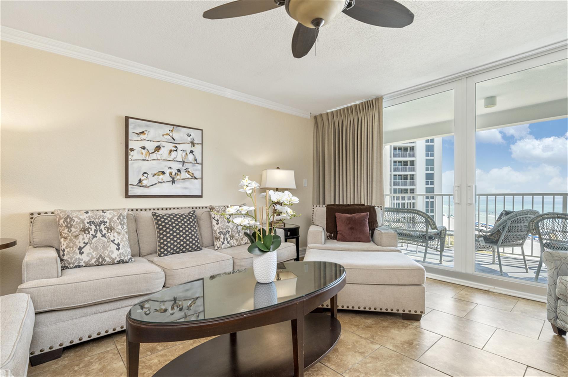 Relax in your sophisticated coastal living room with plush seating and stunning ocean views through floor-to-ceiling windows.