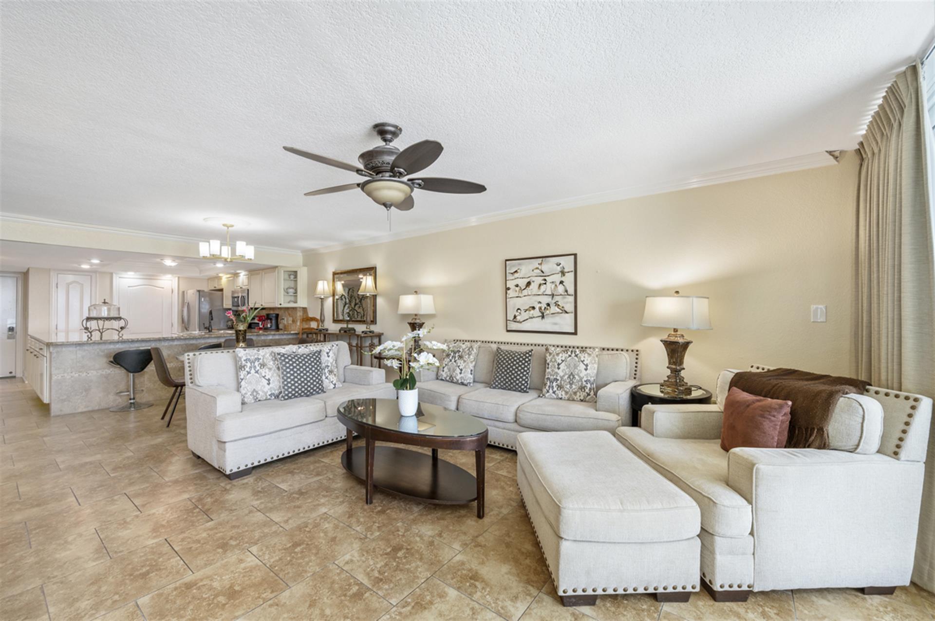 Relax in your spacious living room with plush sectional seating and elegant decor that flows seamlessly into the fully equipped kitchen.