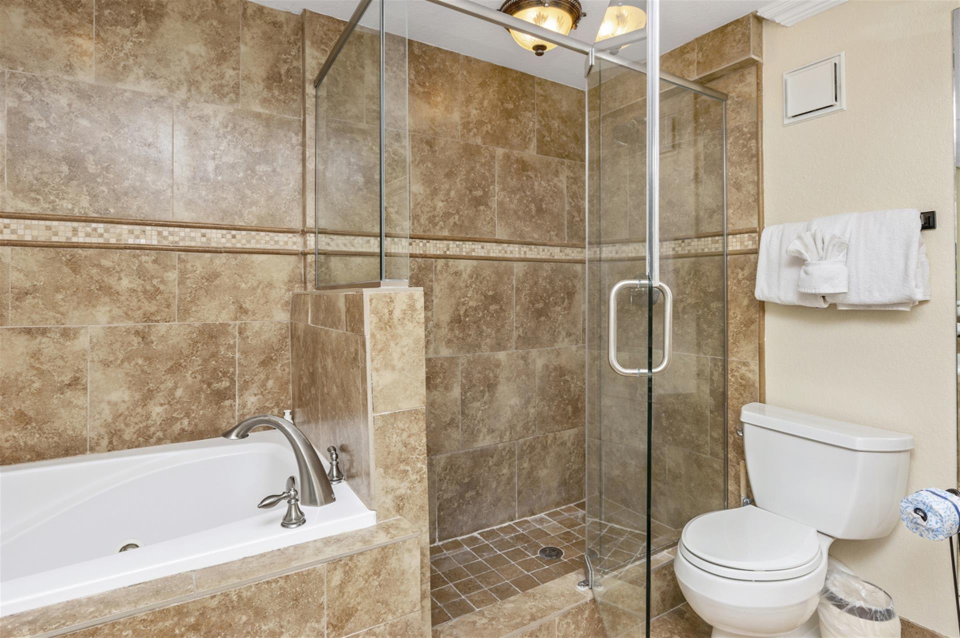Unwind in your luxurious marble bathroom with a deep soaking tub and spacious glass shower after exploring the day.