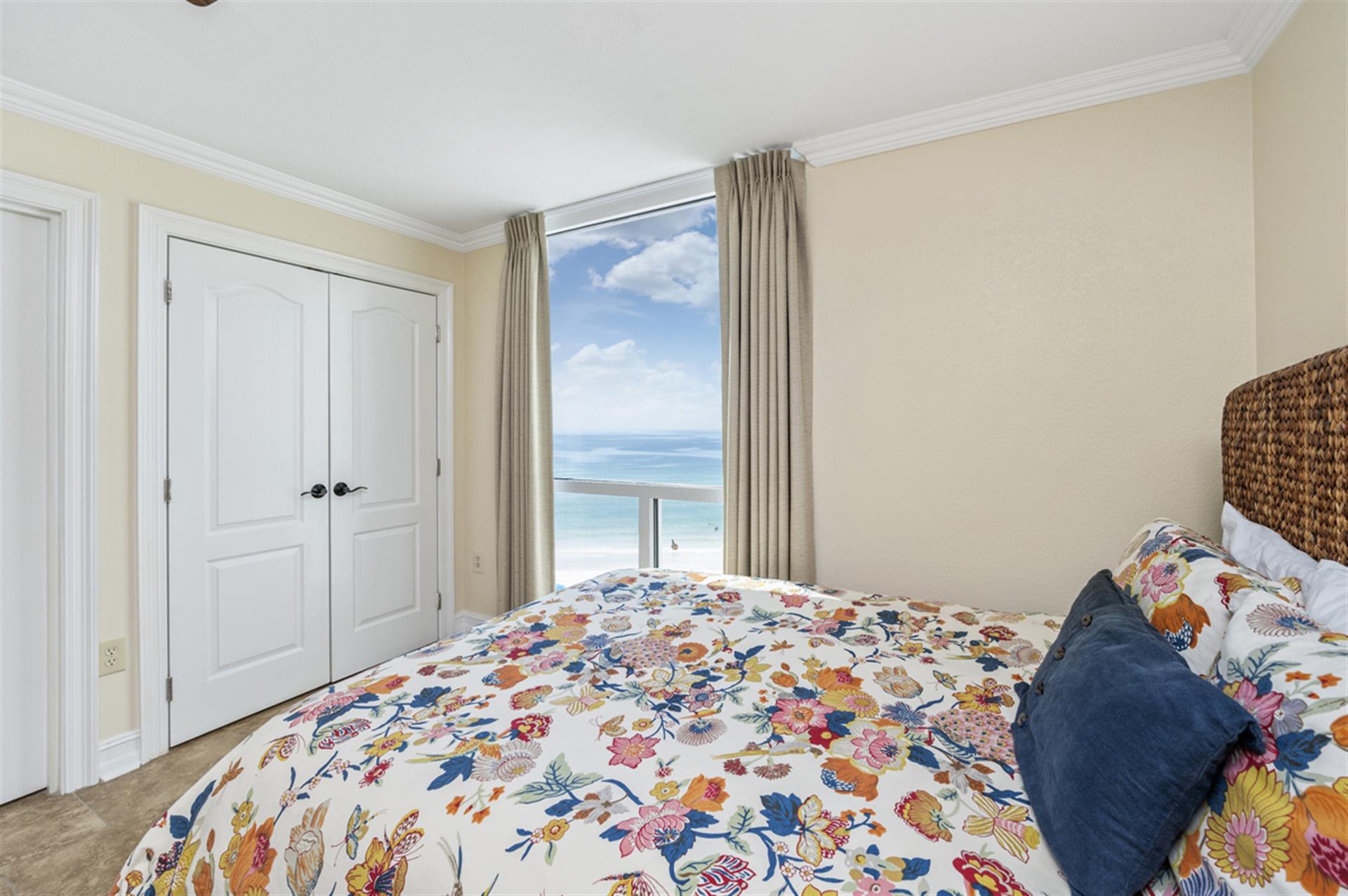 Wake up to stunning ocean views from your coastal bedroom, where vibrant florals and woven textures create a cheerful seaside retreat.