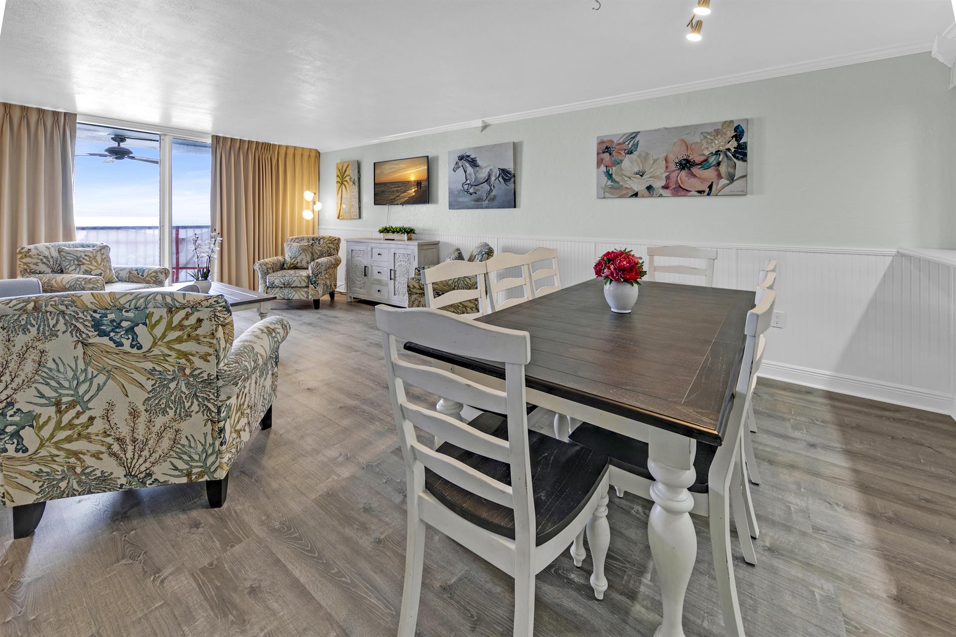 Gather around your dining table while taking in ocean views through floor-to-ceiling windows in this bright, art-filled space.