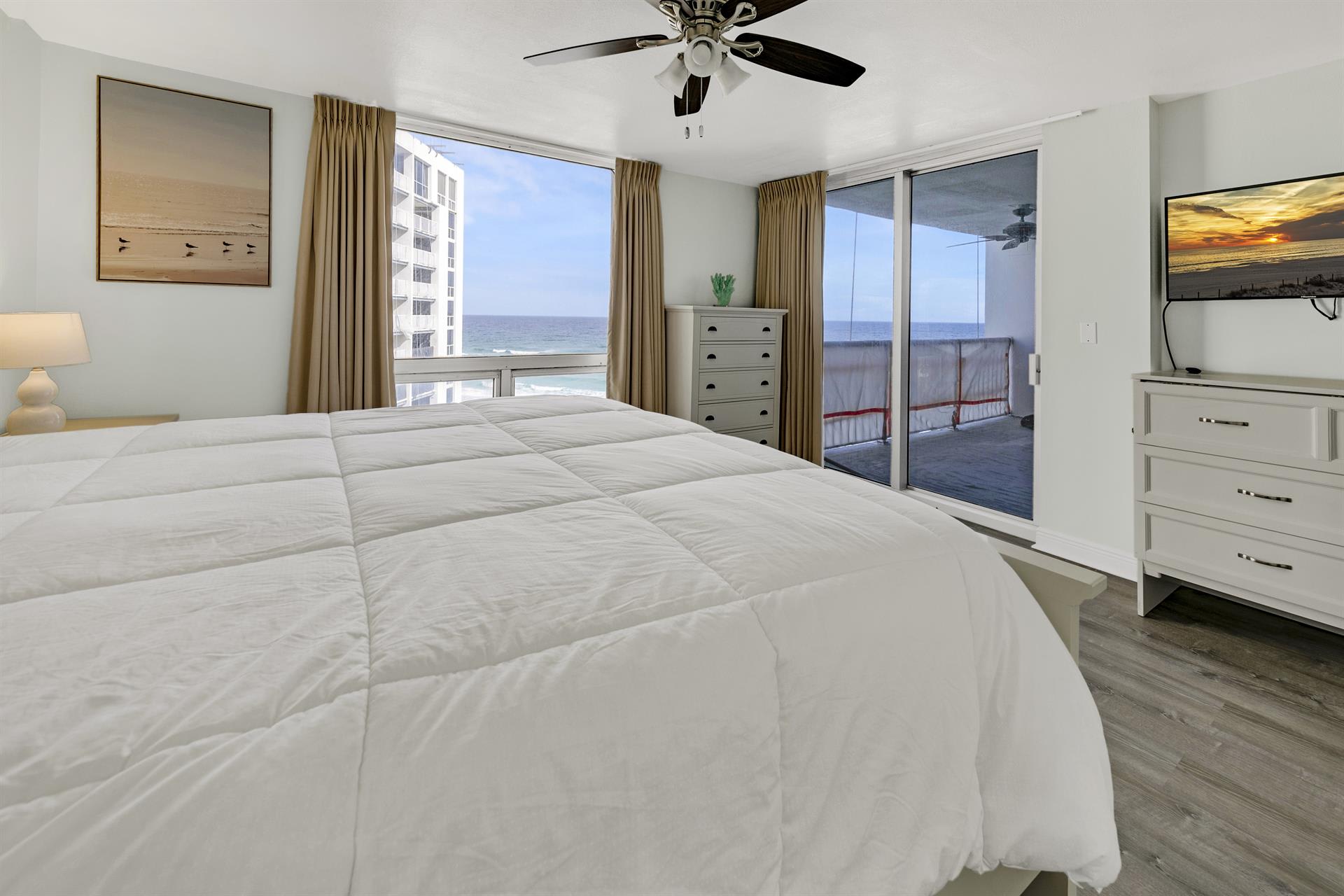 Wake to stunning ocean views through floor-to-ceiling windows in your serene bedroom retreat with plush bedding and private balcony access.